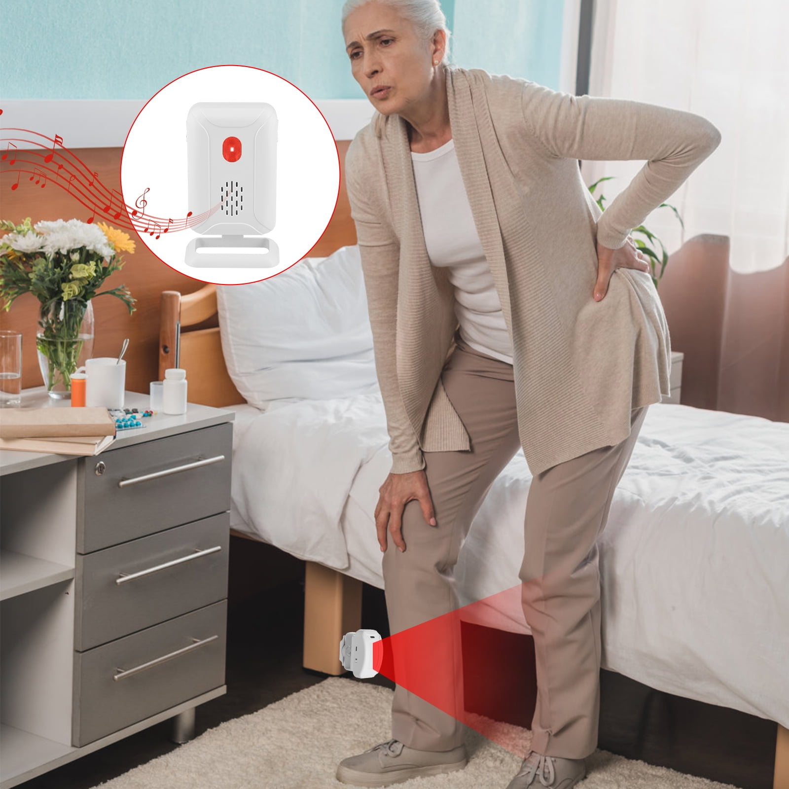 Ältere Frau mit Rückenschmerzen neben einem Bett, ein Alarmgerät ist zu sehen.