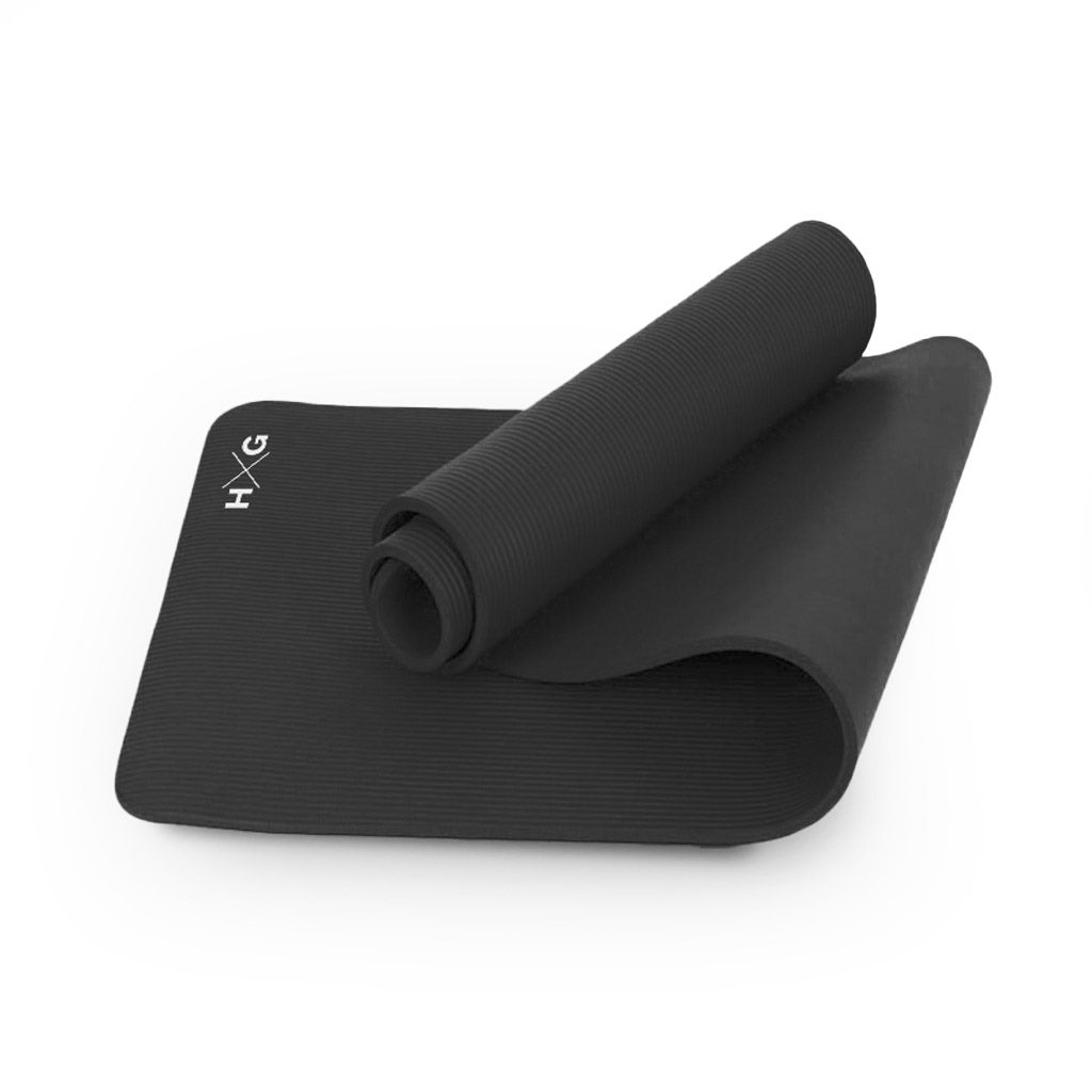Una esterilla de yoga negra, parcialmente enrollada, con textura acanalada y logo blanco.