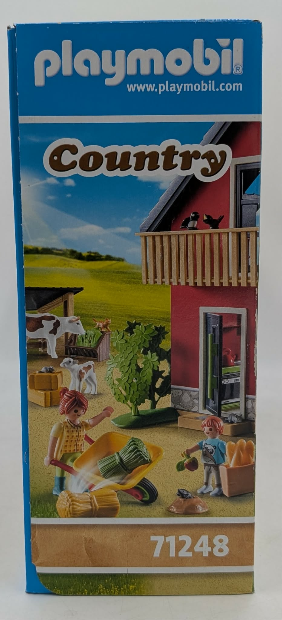 Playmobil Bauernhof-Szene mit Kühen, Katze, Bauern und einem Wagen mit Heu.