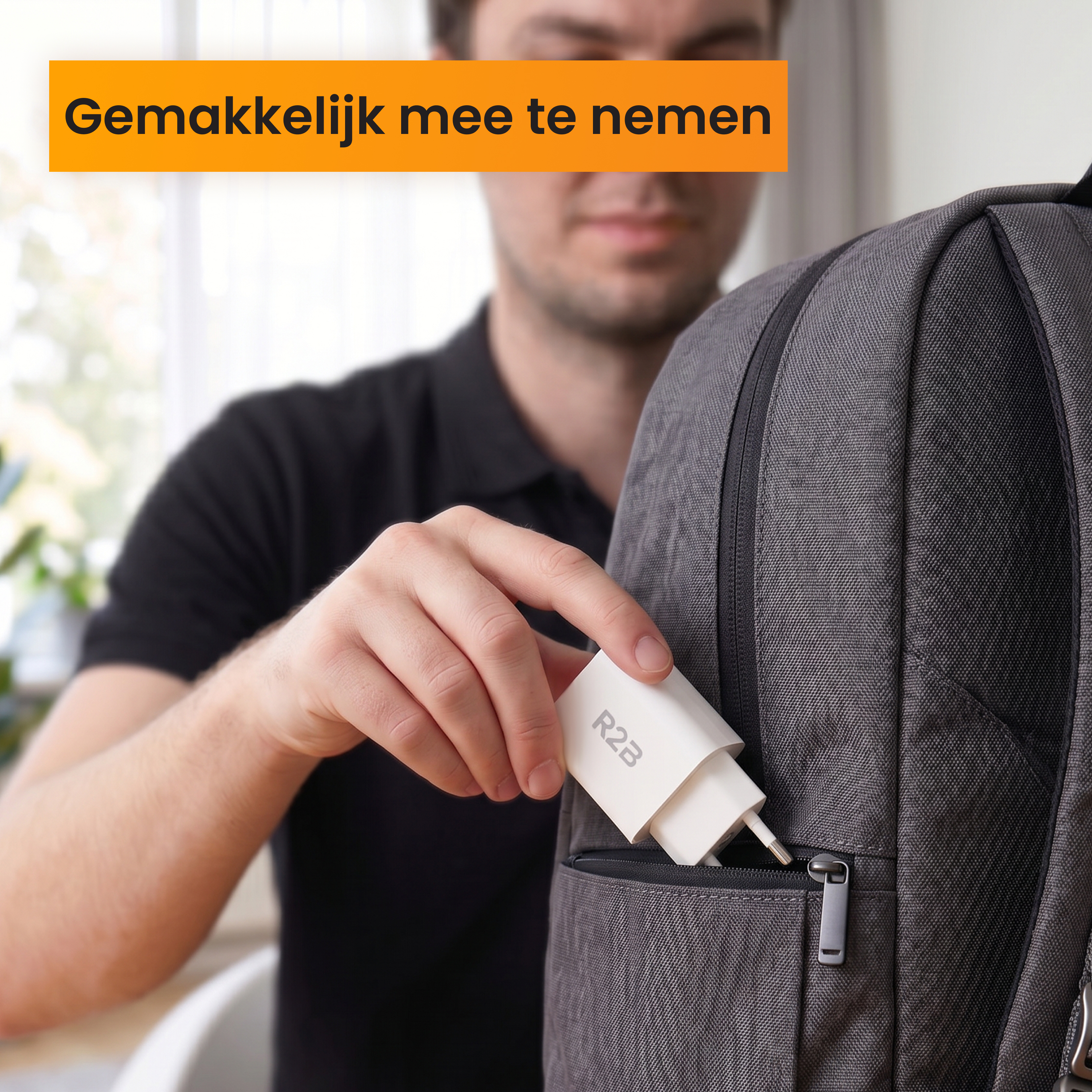 Een hand stopt een witte R2B oplader in een grijs rugzakvak.