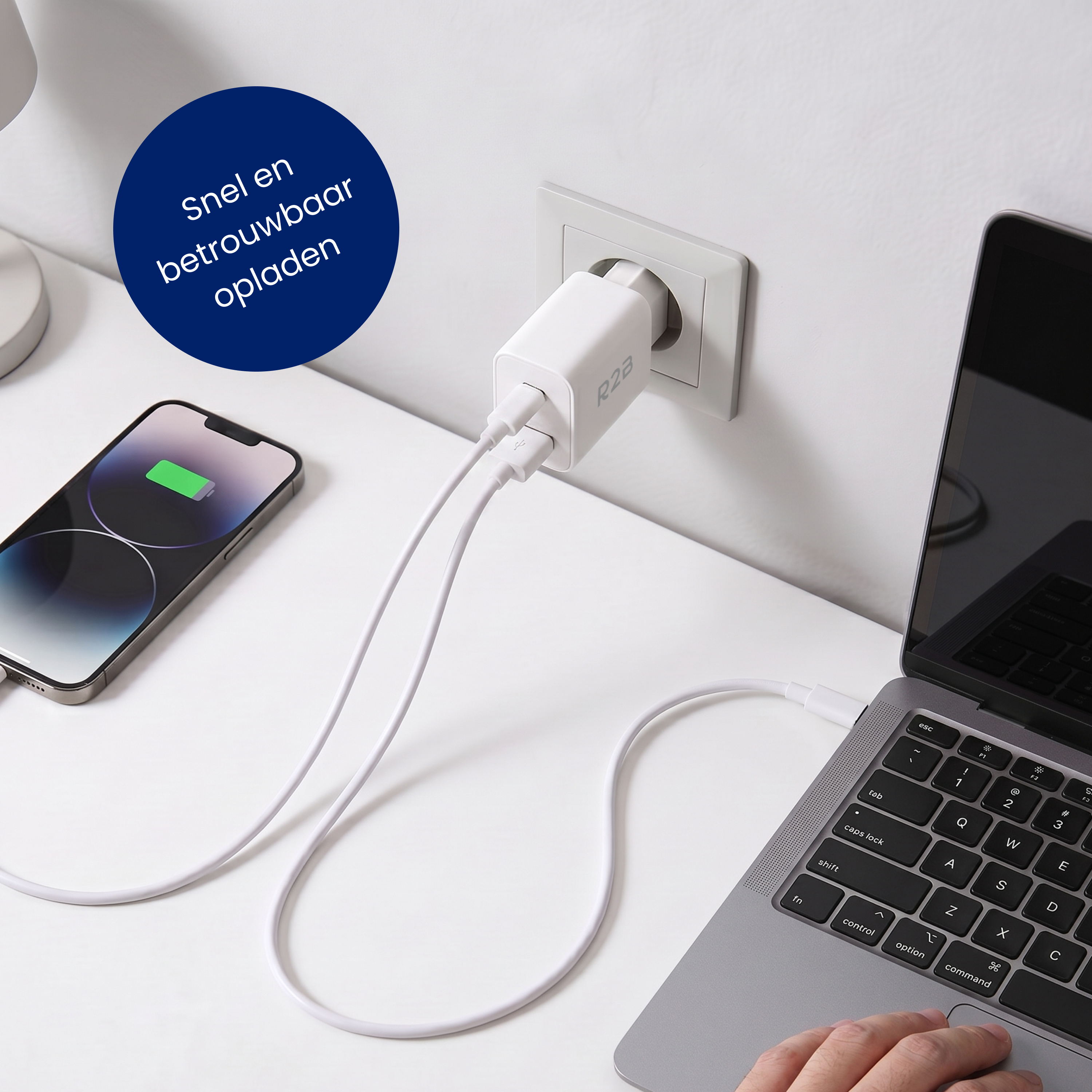 Un adaptateur de charge blanc à deux ports USB charge un iPhone et un ordinateur portable.