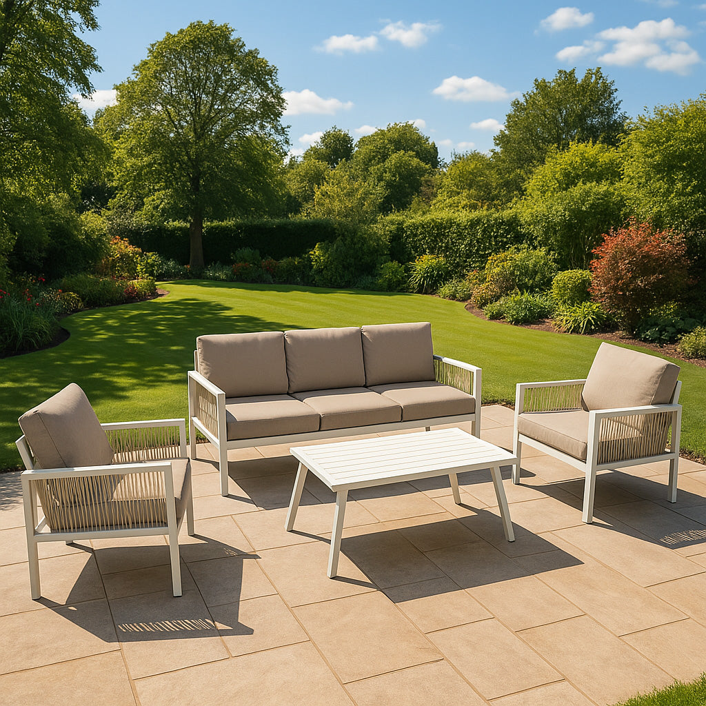 Conjunto de muebles de exterior con sofá, dos sillones y mesa en un patio con césped y árboles.