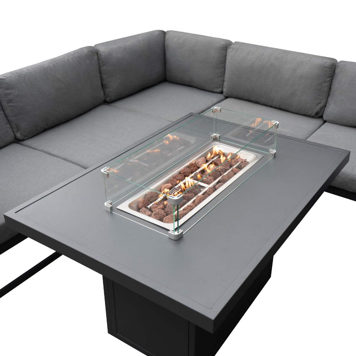 Sofá seccional gris rodea mesa de centro con hoguera y guardavientos de cristal.