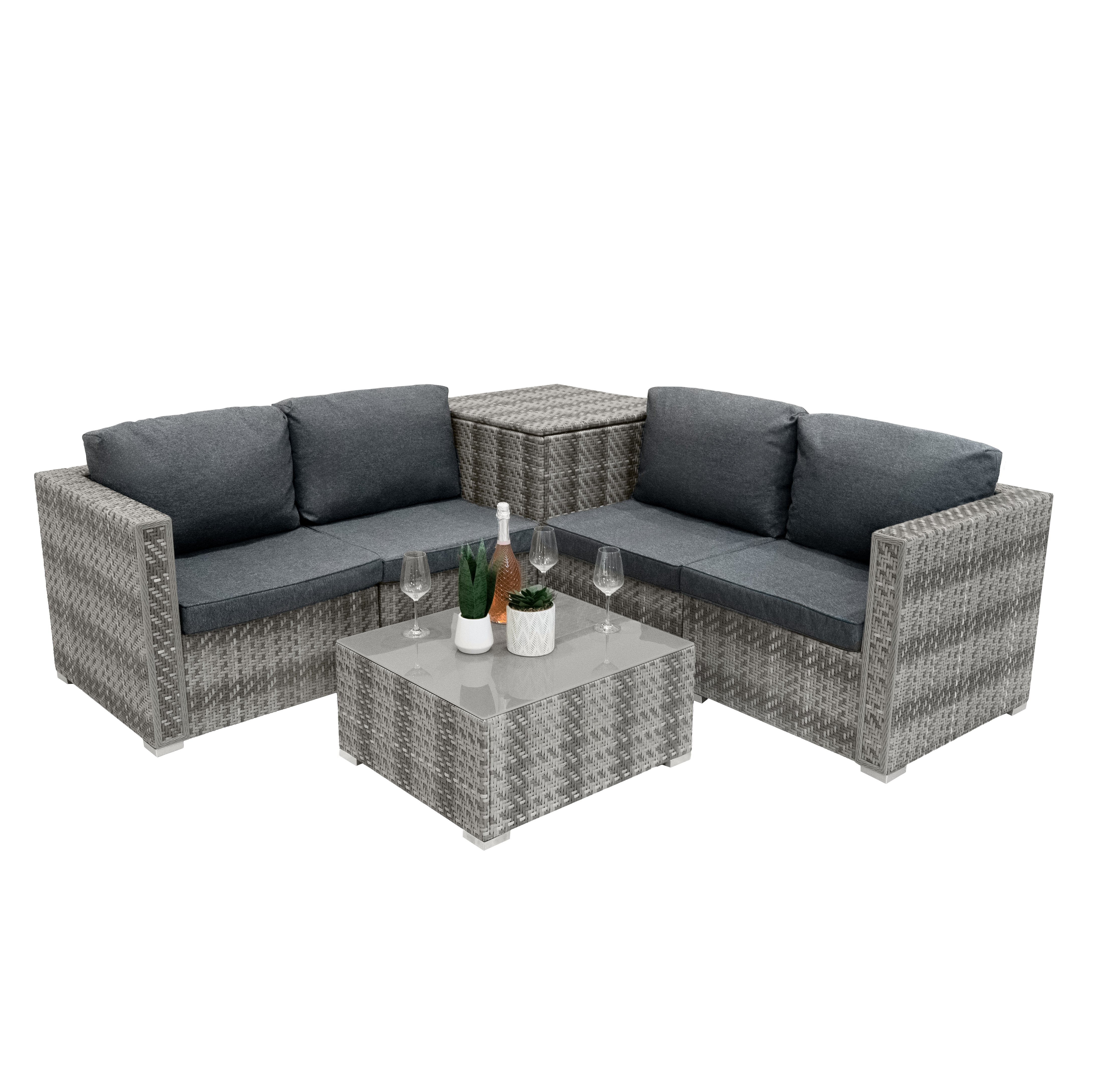Sofá seccional de ratán gris con mesa, vasos y botellas.