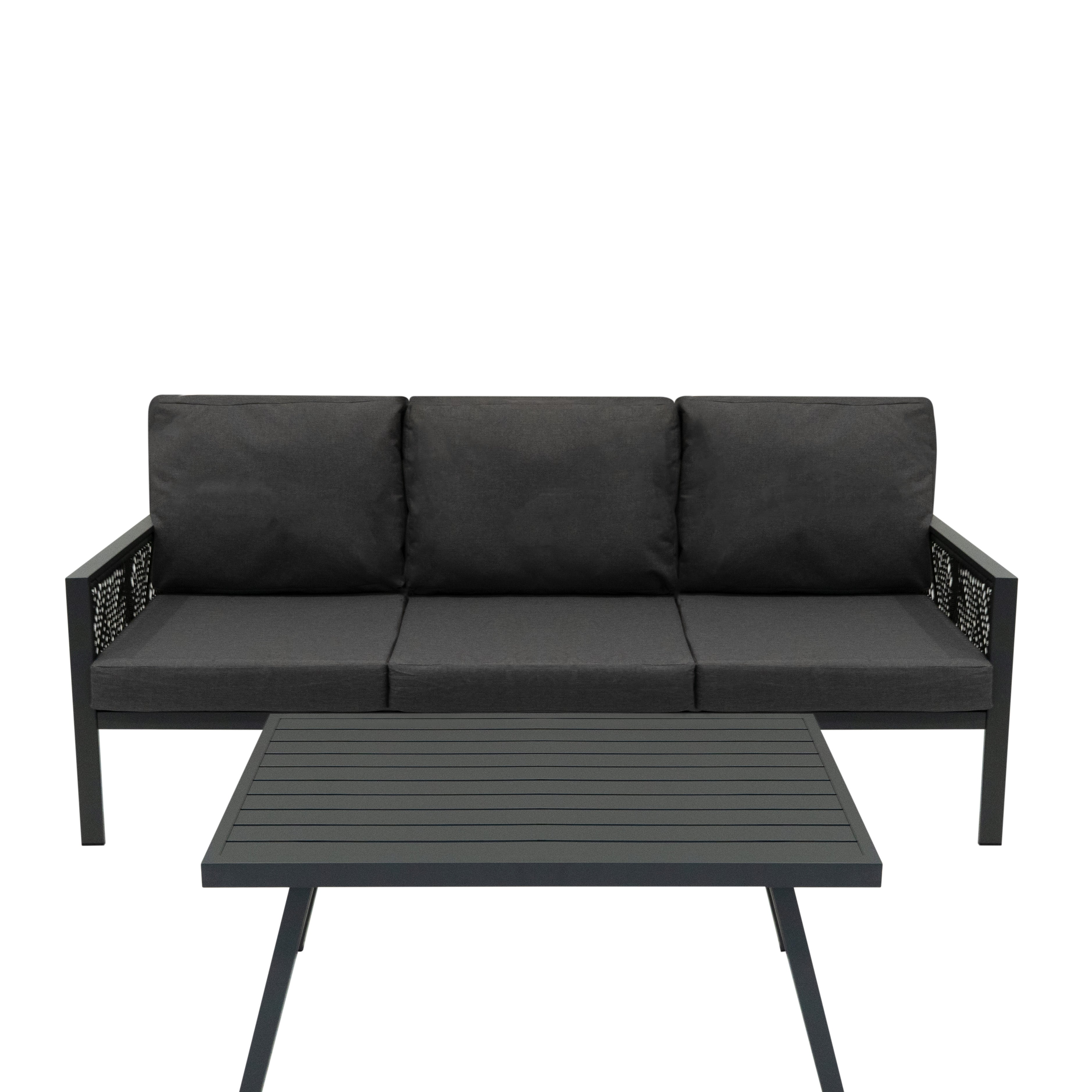 Un sofá oscuro para exteriores con tres cojines y una mesa a juego.