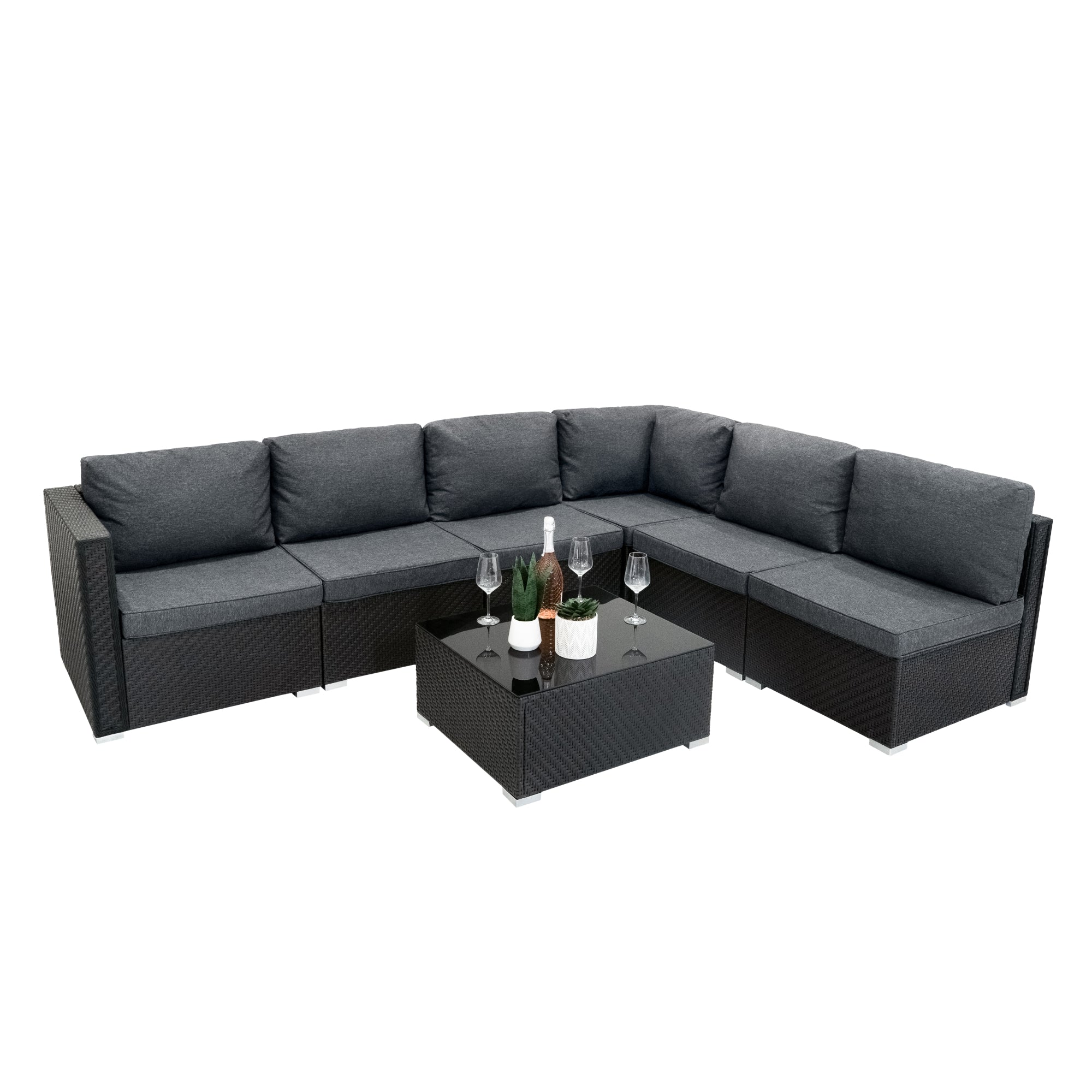 Sofá modular exterior gris oscuro con mesa a juego que sostiene una botella de vino y copas.