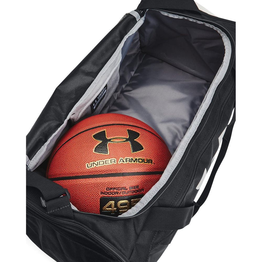 Ein Basketball der Marke Under Armour liegt in einer offenen schwarzen Sporttasche.