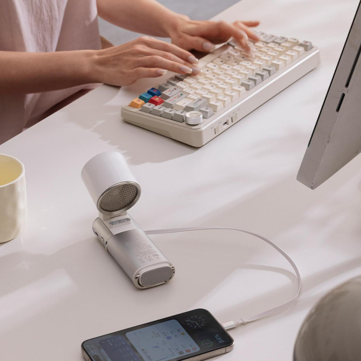 Person tippt auf Tastatur. Weiße tragbare Lautsprecher mit Handy verbunden.