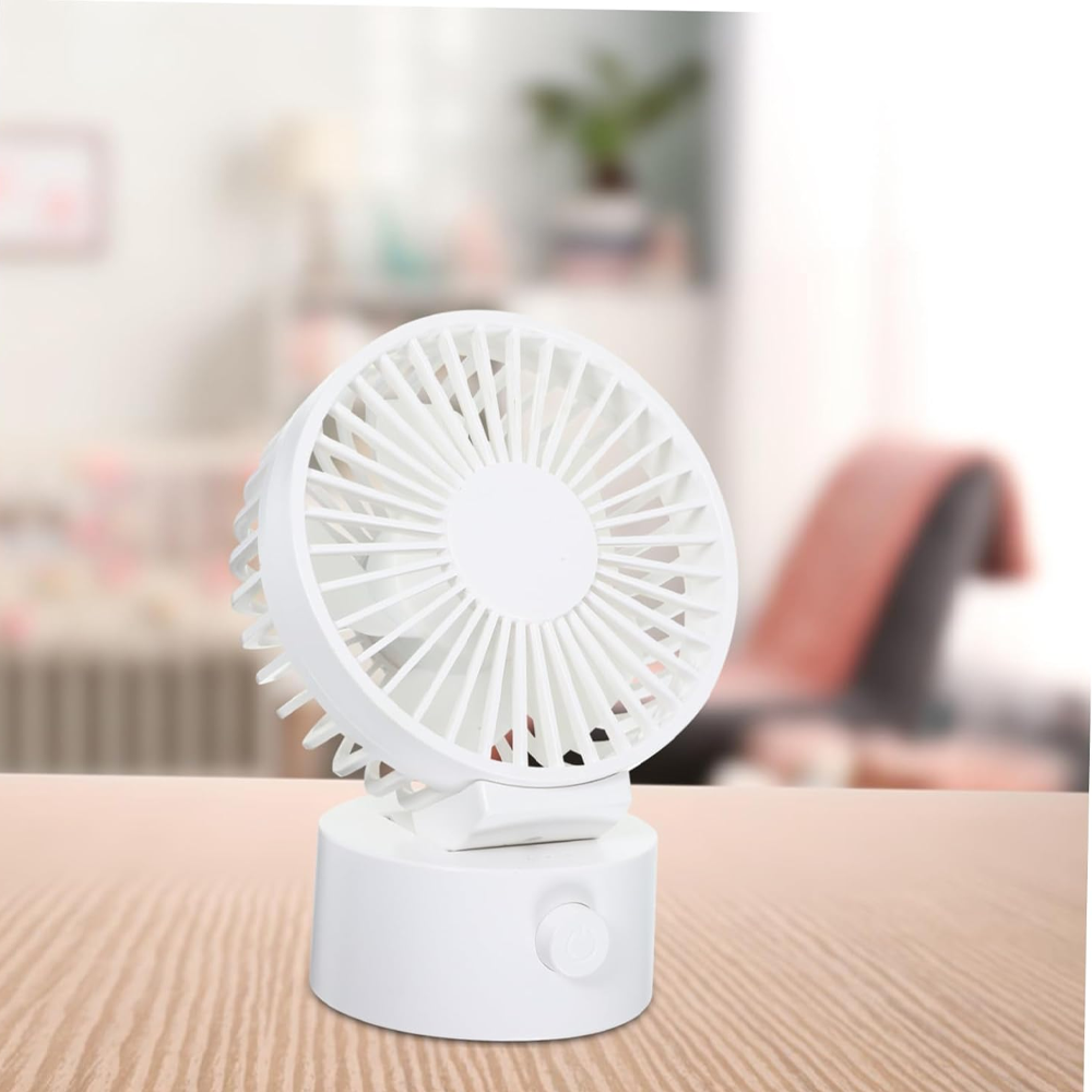 Ein weißer Tischventilator mit Drehknopf steht auf einem Holztisch.