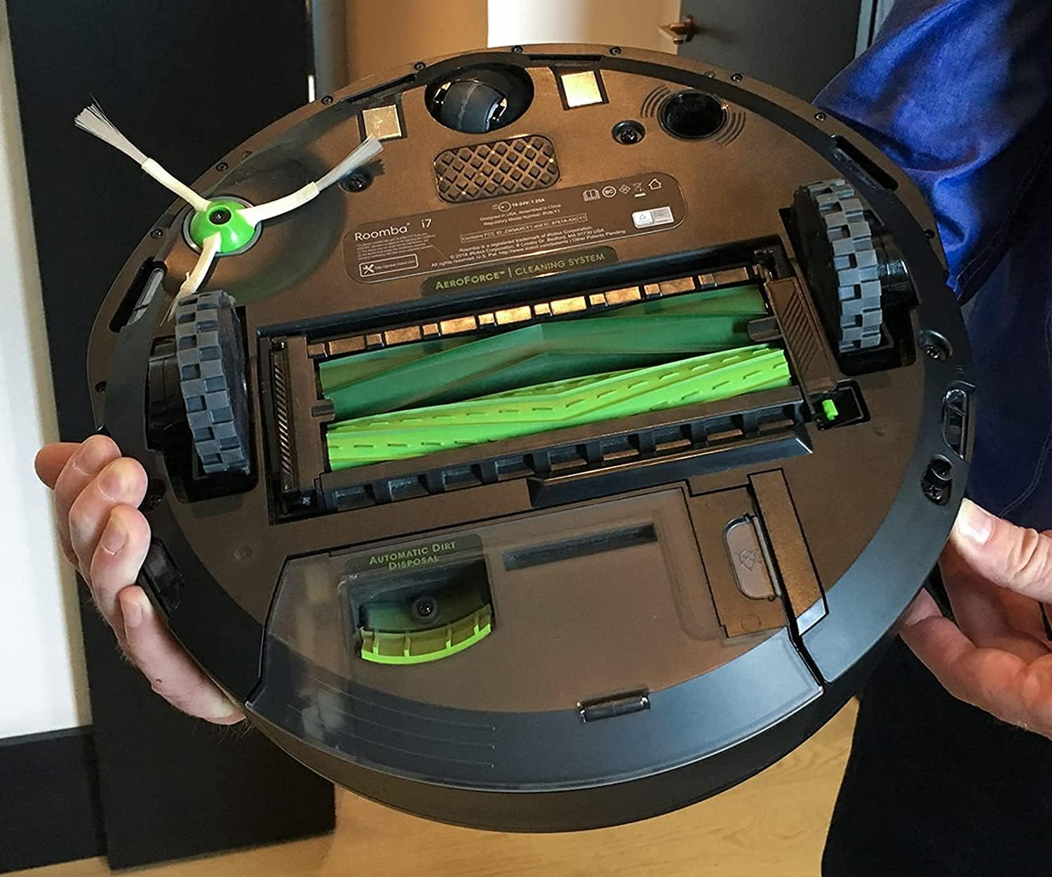 Unteransicht des iRobot Roomba i7 mit Schuttentsorgungsbehälter und grünen Rollen.