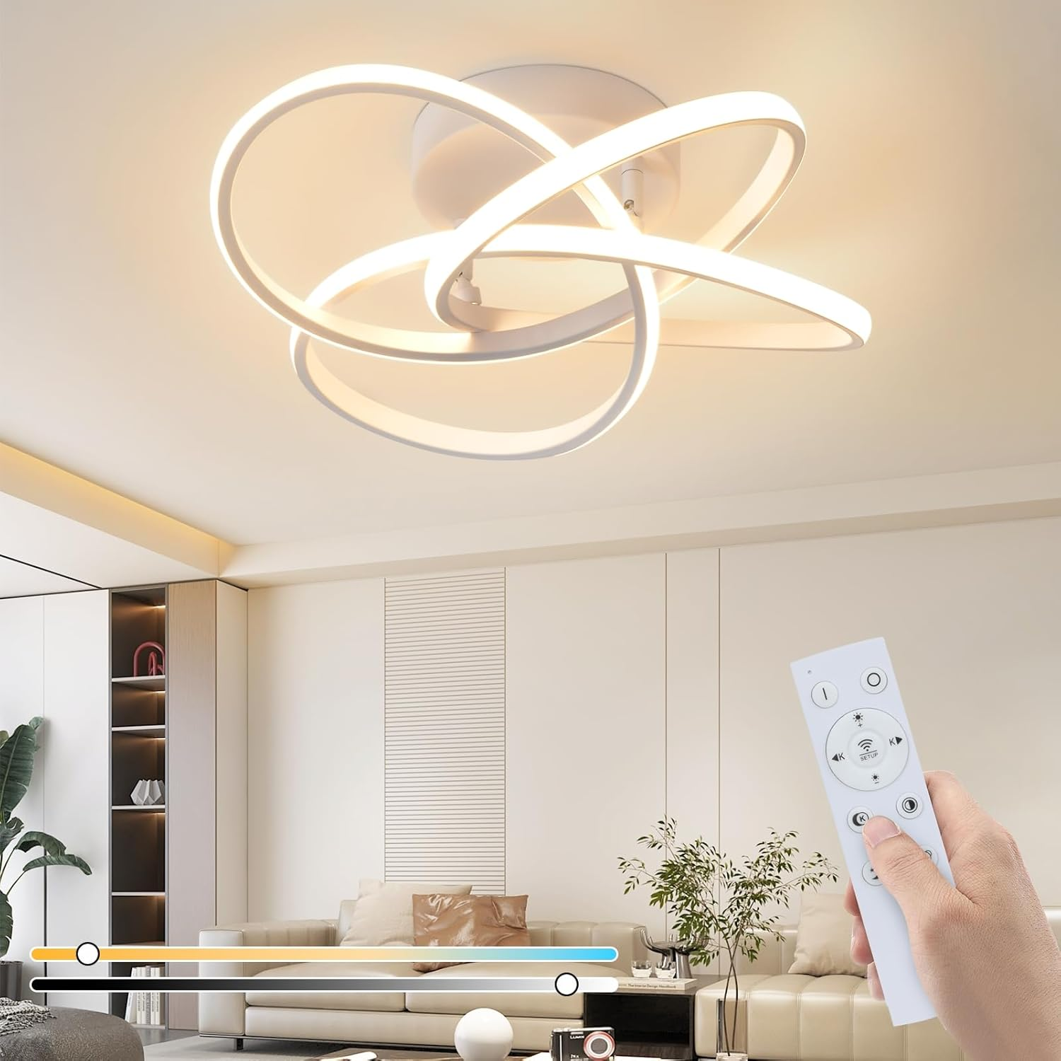 Moderne weiße Deckenleuchte mit verschlungenen Ringen, Fernbedienung in der Hand.