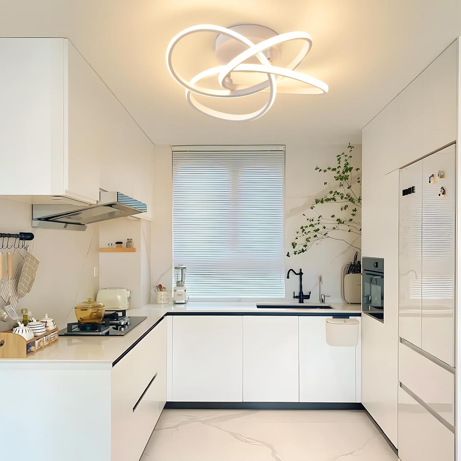 Eine moderne weiße Küche mit einem Kochfeld, Kühlschrank und einem Fenster.