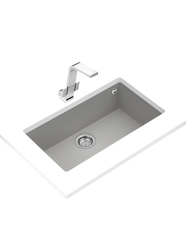 Beyaz tezgah üzerinde parlak krom musluklu gri gömme lavabo.