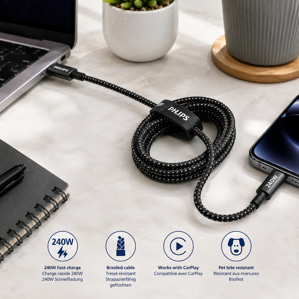 Siyah örgülü USB-C kablosu bir iPhone ve dizüstü bilgisayar şarj ediyor.