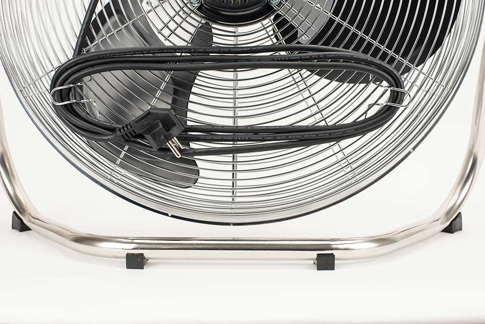 Ein silberner Standventilator mit schwarzem Kabel und Stecker, nahaufnahme.