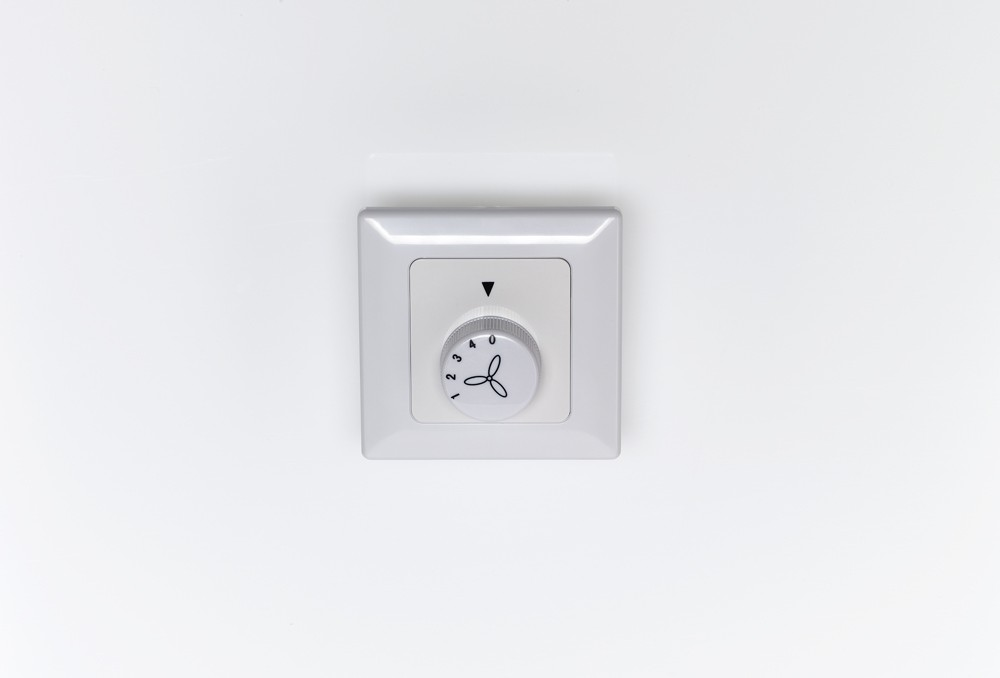 Un controller bianco per la velocità della ventola con quadrante 0-4.