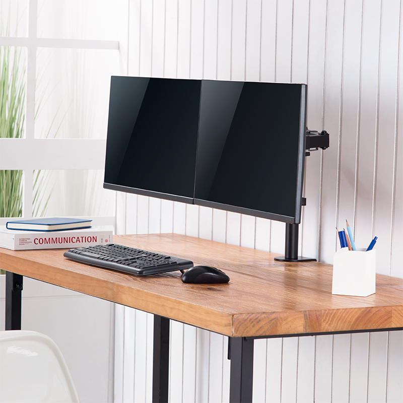 Ein Schreibtisch mit zwei Monitoren, Tastatur, Maus und Büchern.