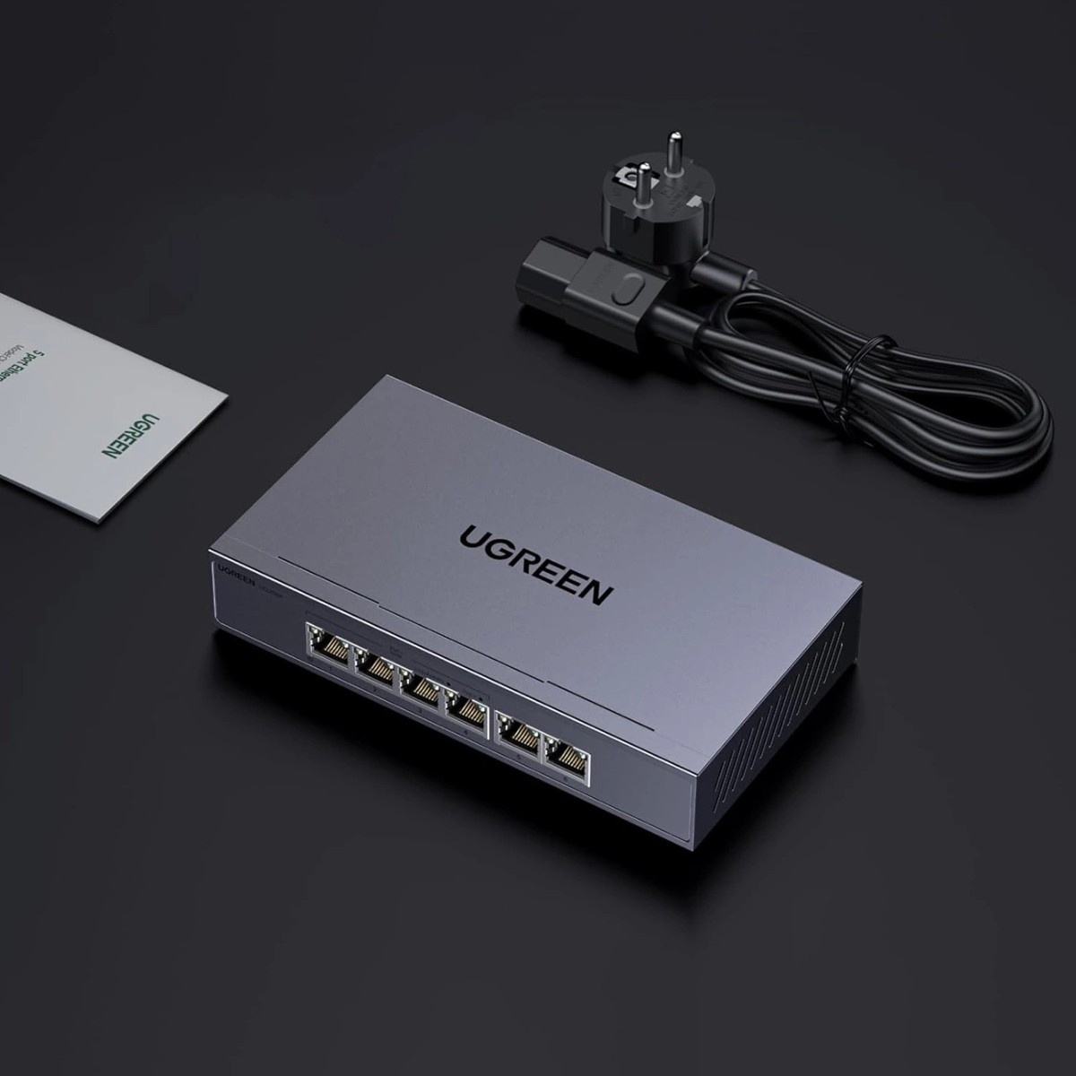 Switch UGREEN grigio a 5 porte, cavo di alimentazione e manuale.