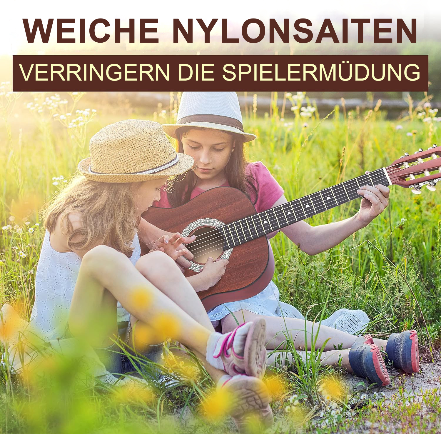 Zwei Mädchen sitzen im Gras und spielen Gitarre.