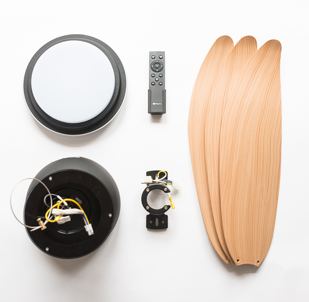Teile eines Deckenventilators: Licht, Fernbedienung, Motor und Holzflügel.