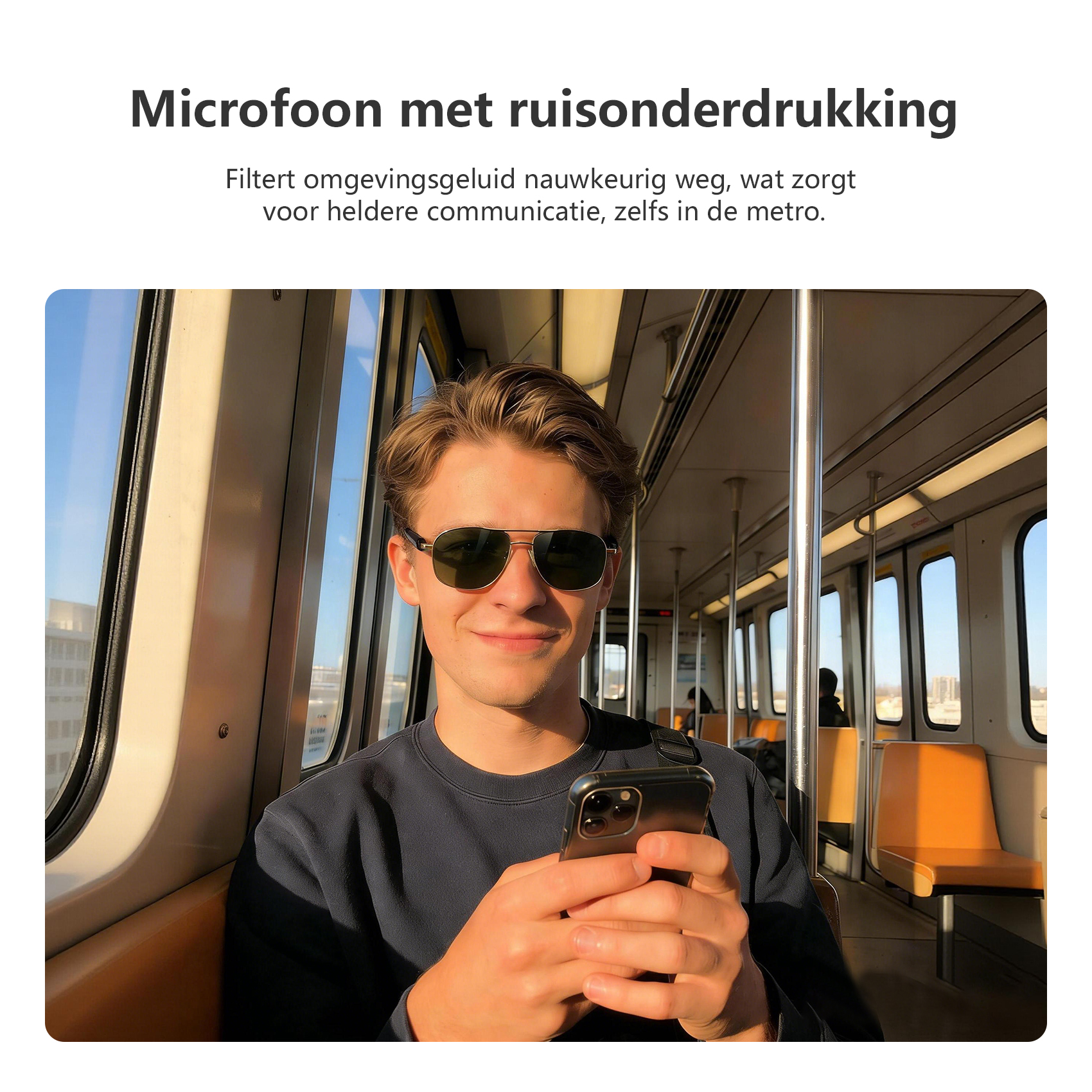 A man in sunglasses holds a phone on a train, with seats and windows visible.