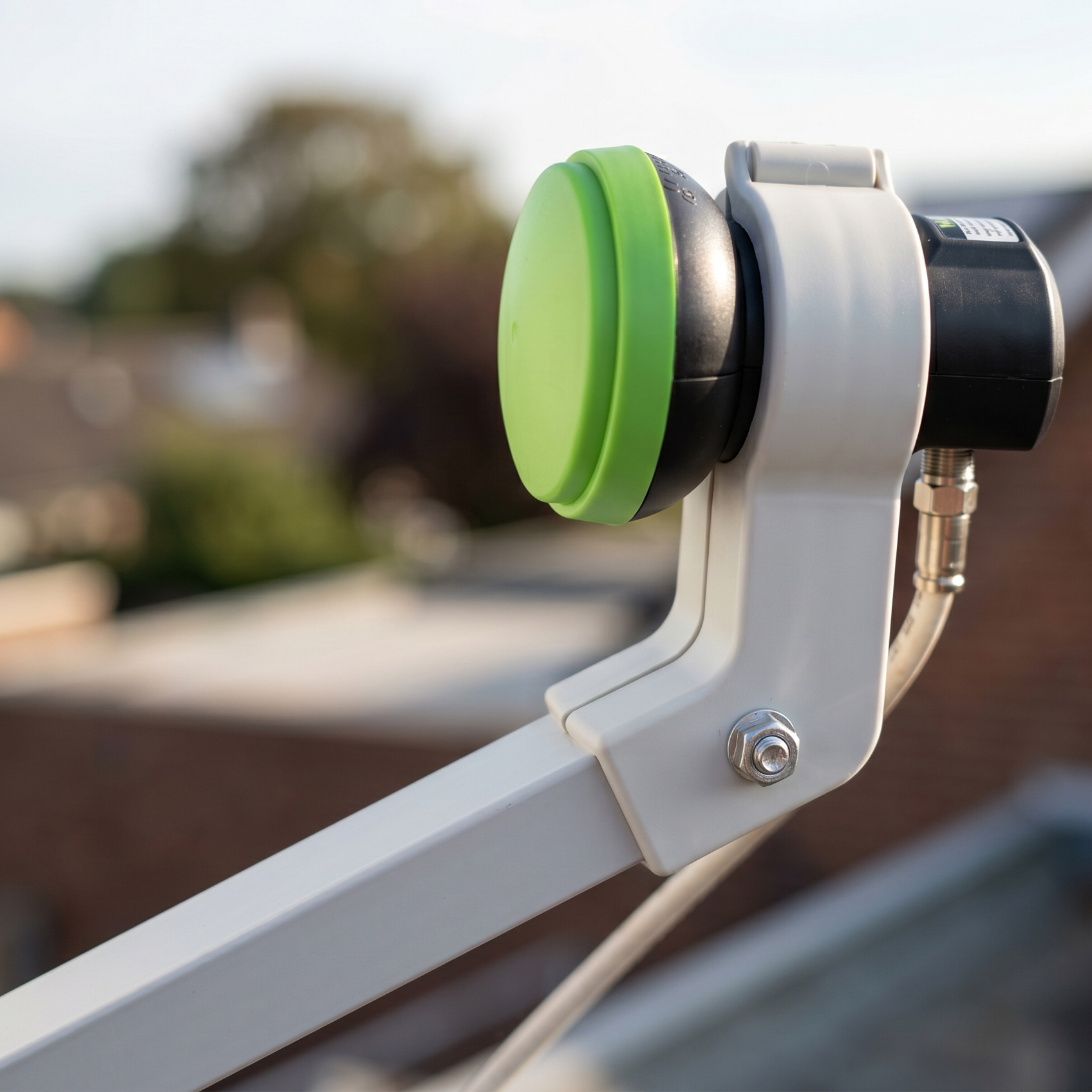 Nahaufnahme eines LNB mit grünem Aufsatz, montiert auf einer Satellitenschüssel.