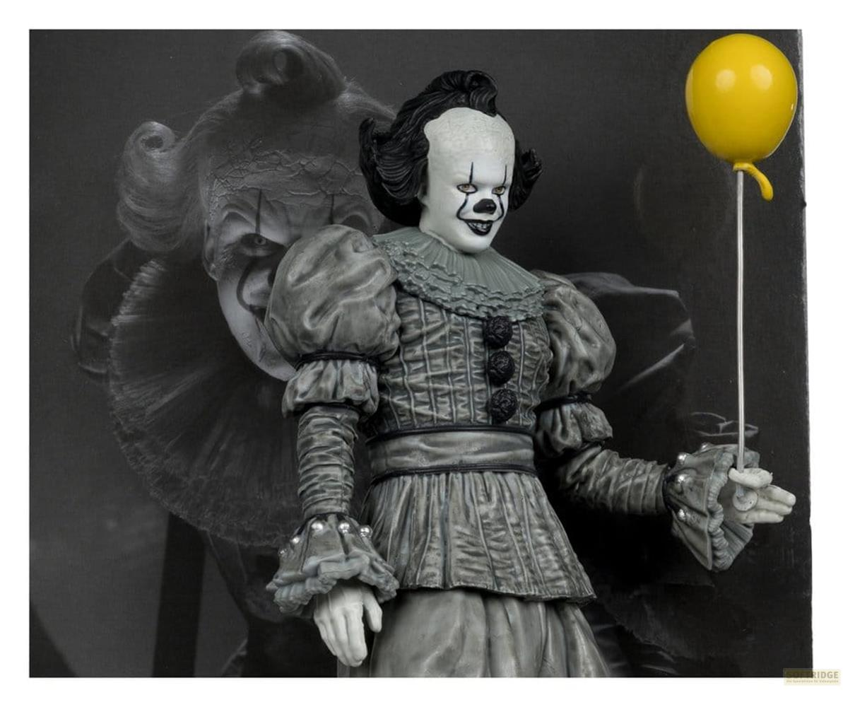 Eine Figur des gruseligen Clowns Pennywise hält einen gelben Ballon. Grau und weiß.