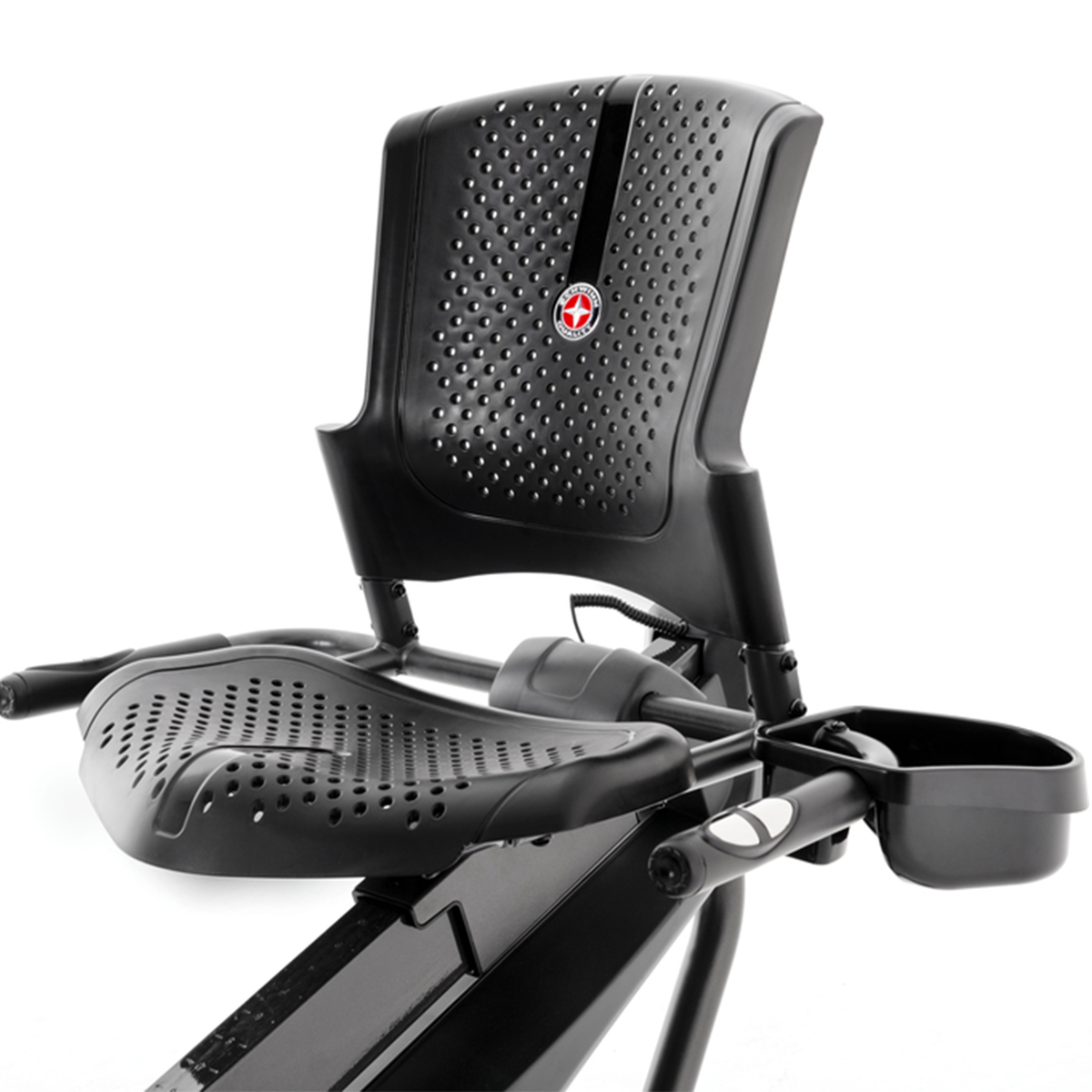 Un asiento de bicicleta de ejercicio negro con agujeros de ventilación y un portavasos.