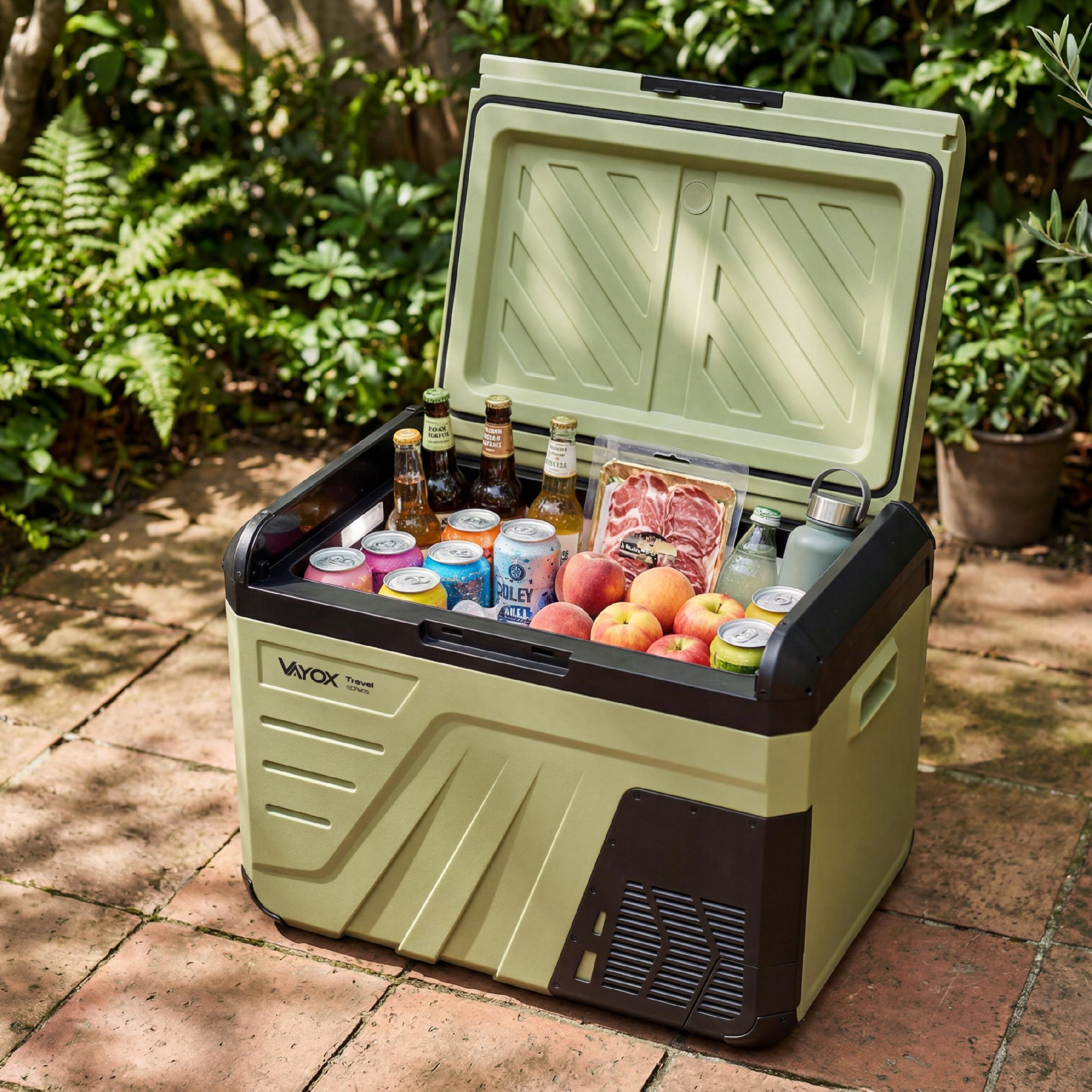 Ein offener Kühlbox mit Getränken, Obst und Fleisch im Freien auf einer gepflasterten Terrasse.
