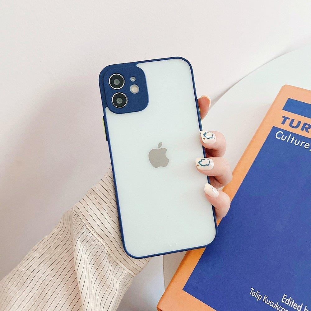 Eine Hand hält ein weißes iPhone mit blauem Rand neben einem Buch.