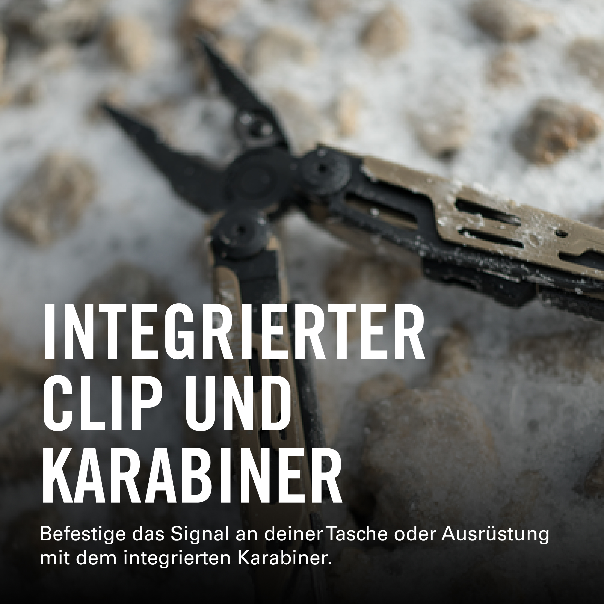Ein Multitool mit integriertem Clip und Karabiner liegt auf Steinen.