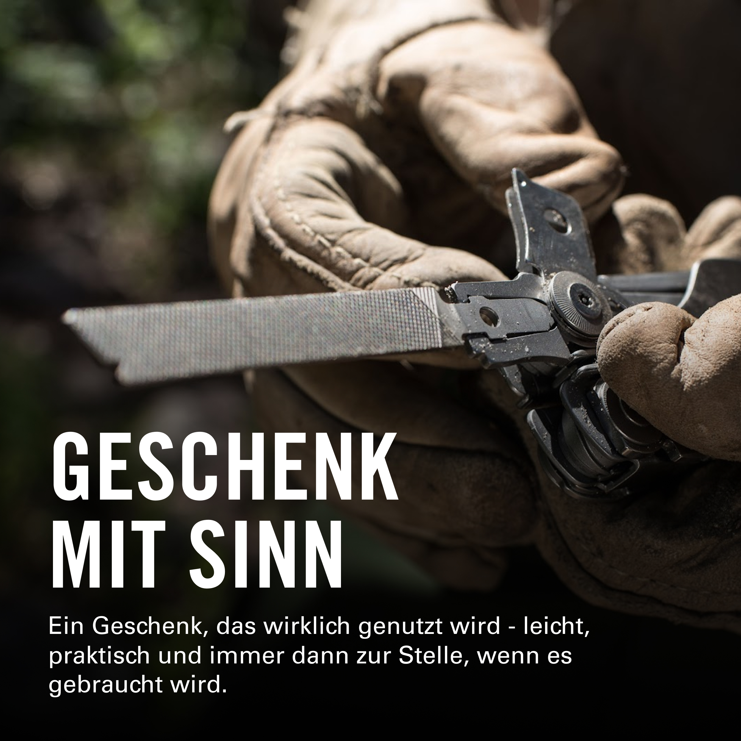 Hände in Arbeitshandschuhen halten ein Multitool mit einer Feile.