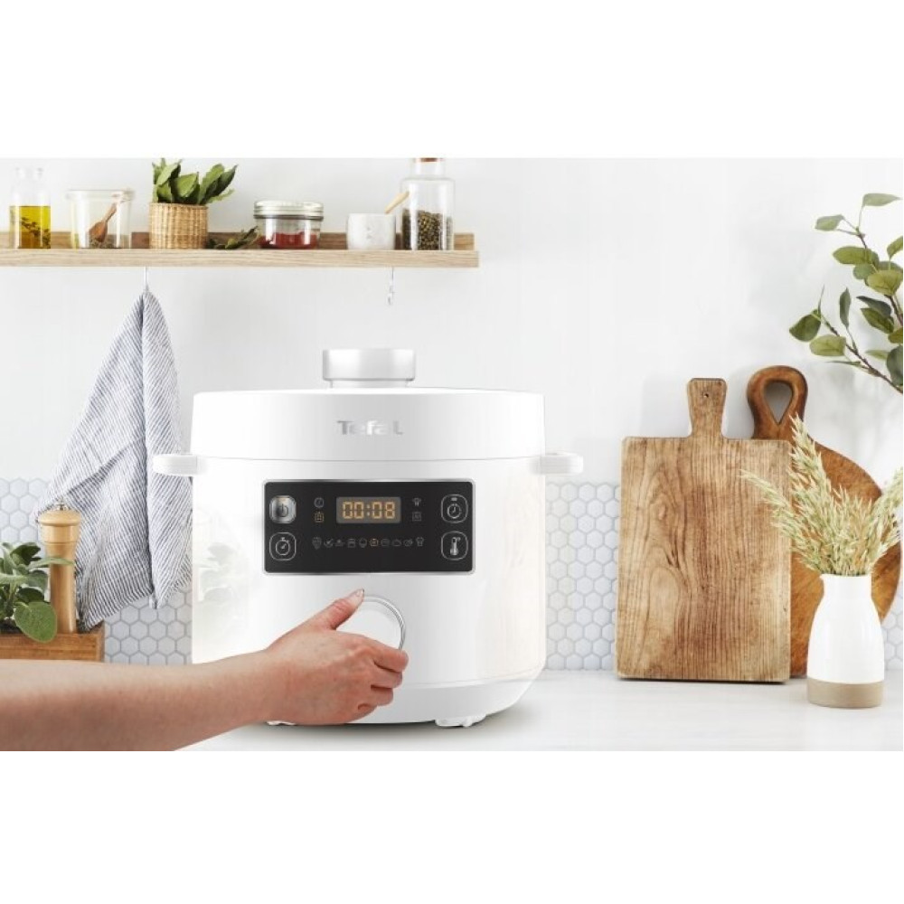 Biały szybkowar Tefal z cyfrowym wyświetlaczem i ręką obracającą pokrętło.