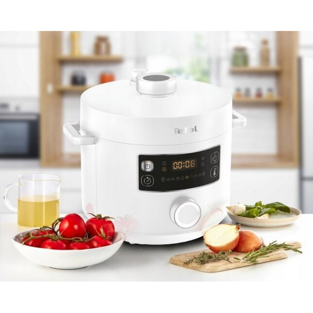 Biały szybkowar Tefal z wyświetlaczem, obok pomidory, cebula i zioła.
