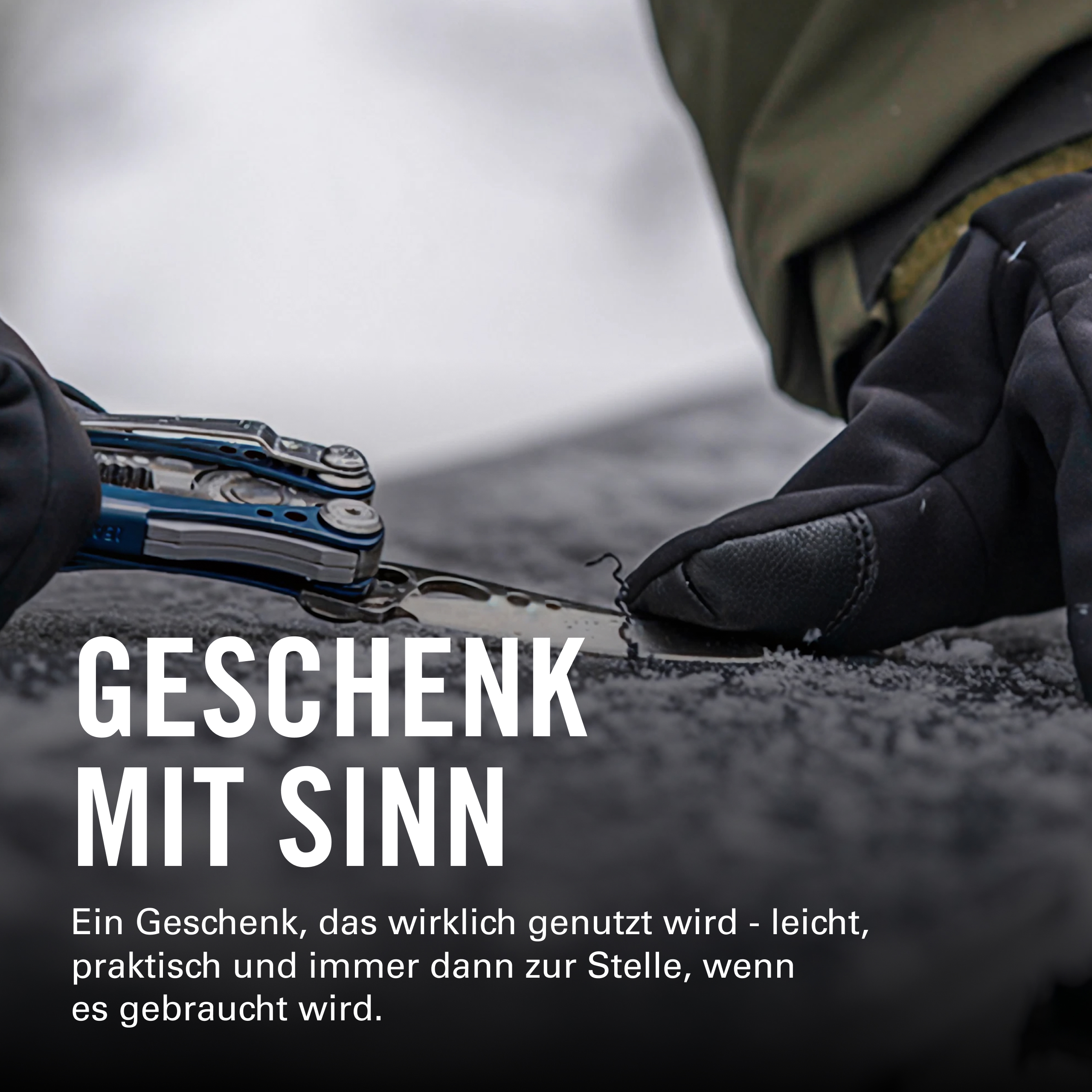Ein Mann mit Handschuhen hält ein Multitool in einer verschneiten Landschaft.