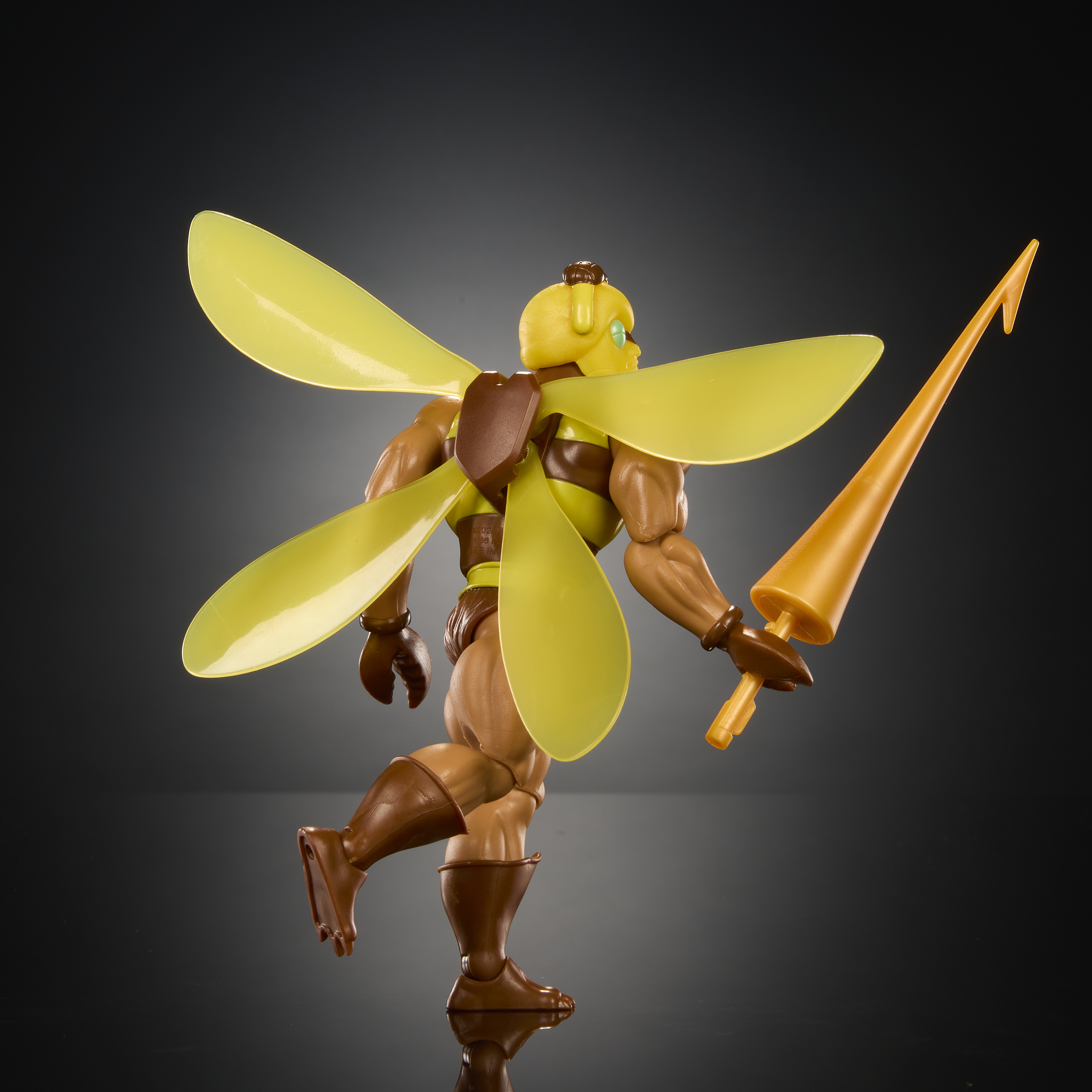 Figura de acción de juguete con cabeza amarilla, alas y arma naranja.