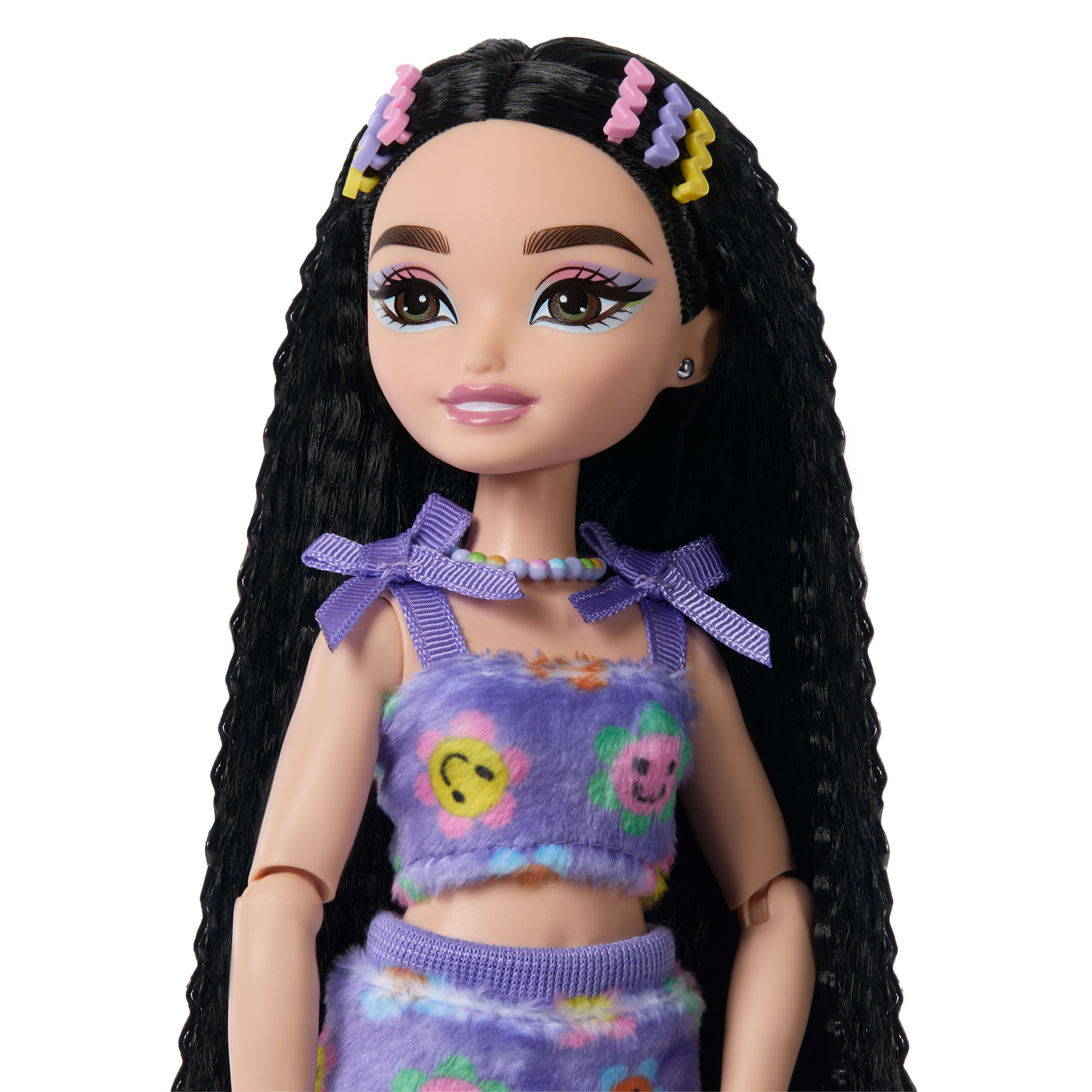 Puppe mit langen schwarzen Haaren, lila Outfit, Blumenmuster und bunten Haarspangen.