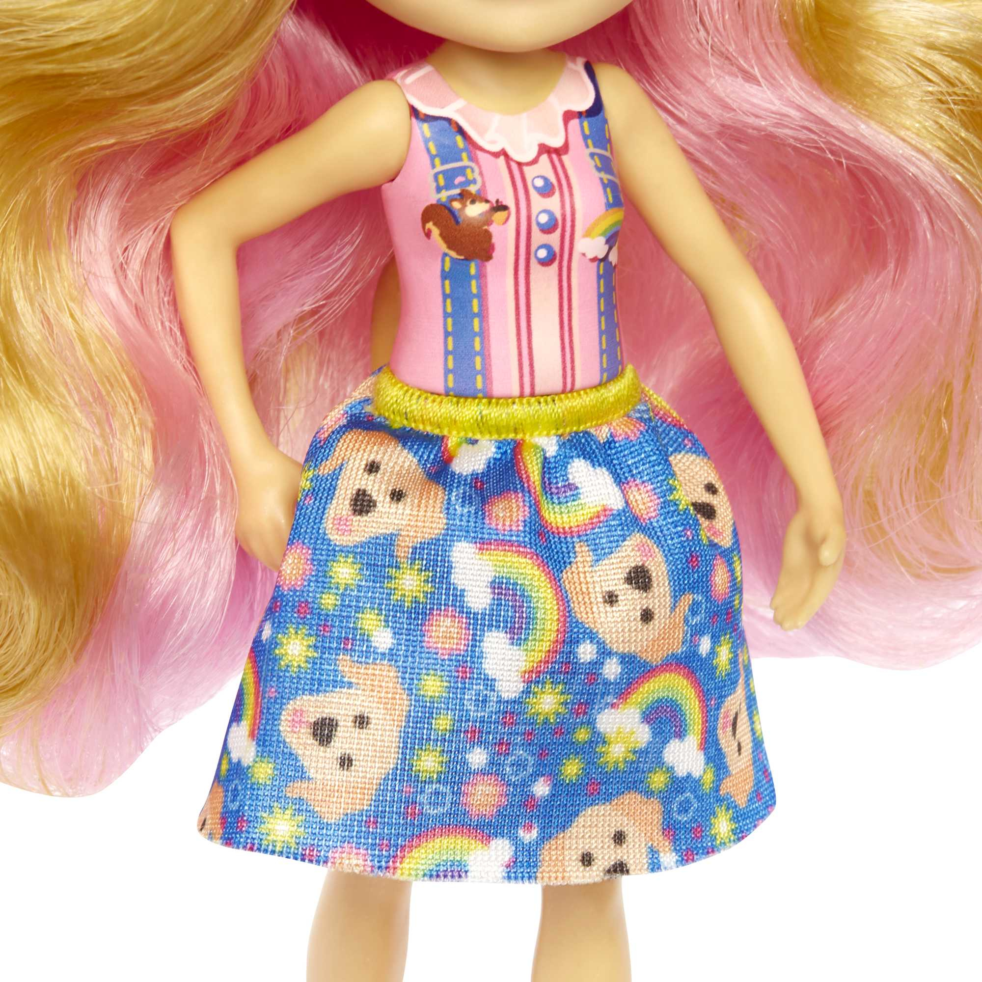 Nahaufnahme einer Puppe mit langen blonden und rosa Haaren, die ein rosa Oberteil mit Eichhörnchen und Regenbogen sowie einen blauen Rock mit Hundegesichtern und Regenbogen trägt.