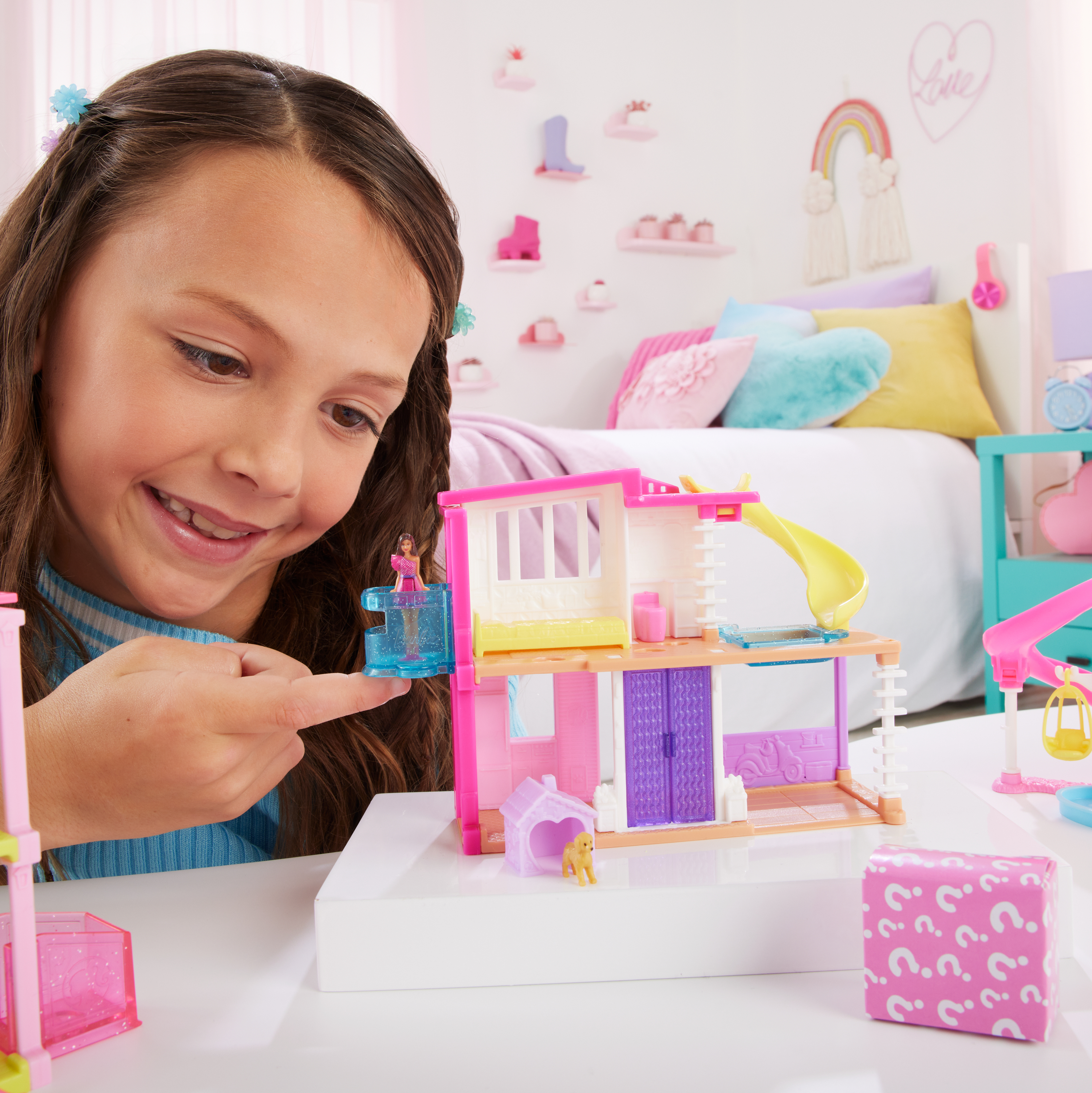 Une fille joue avec une maison de poupée et une petite figurine de chien.