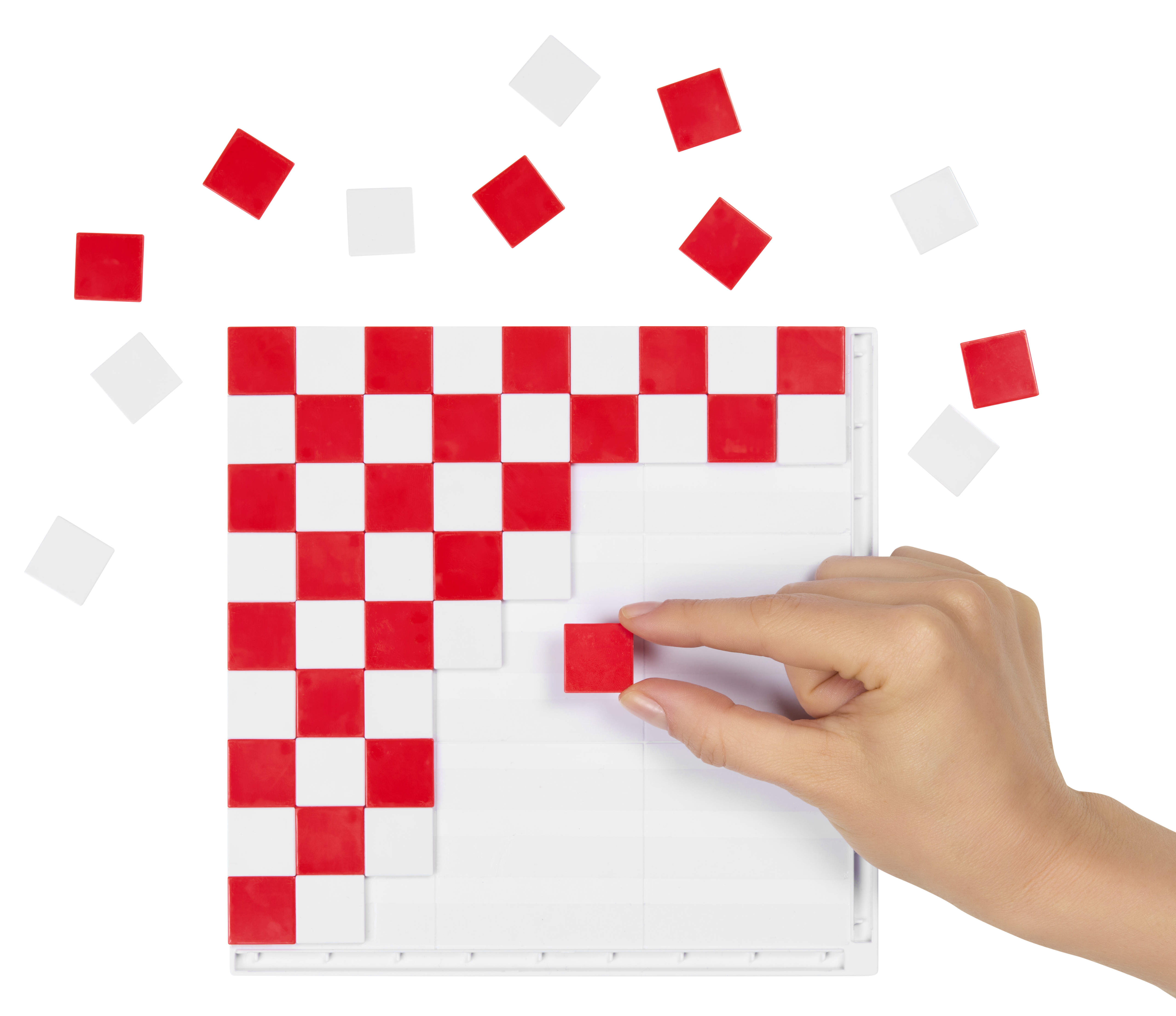 Una mano colocando una ficha cuadrada roja en una cuadrícula blanca, creando un patrón de cuadros rojos y blancos, con fichas dispersas.