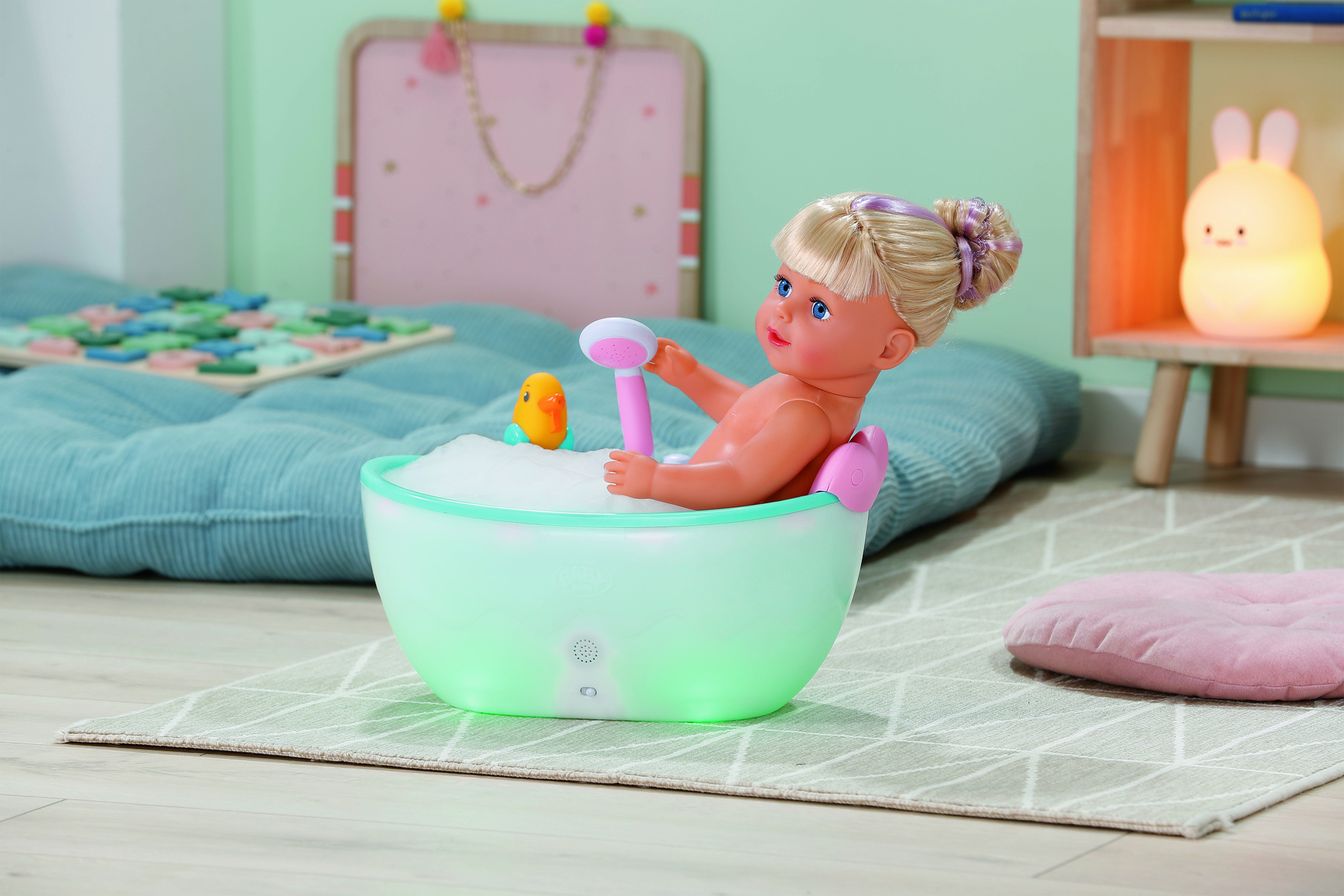 Eine Puppe badet in einer leuchtenden Wanne mit Schaum und Spielzeug.