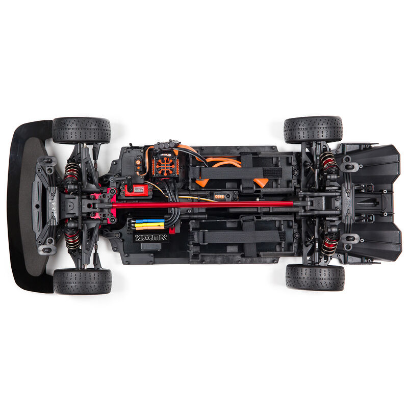 Parte inferior de un coche RC negro con amortiguadores rojos y cables naranjas.