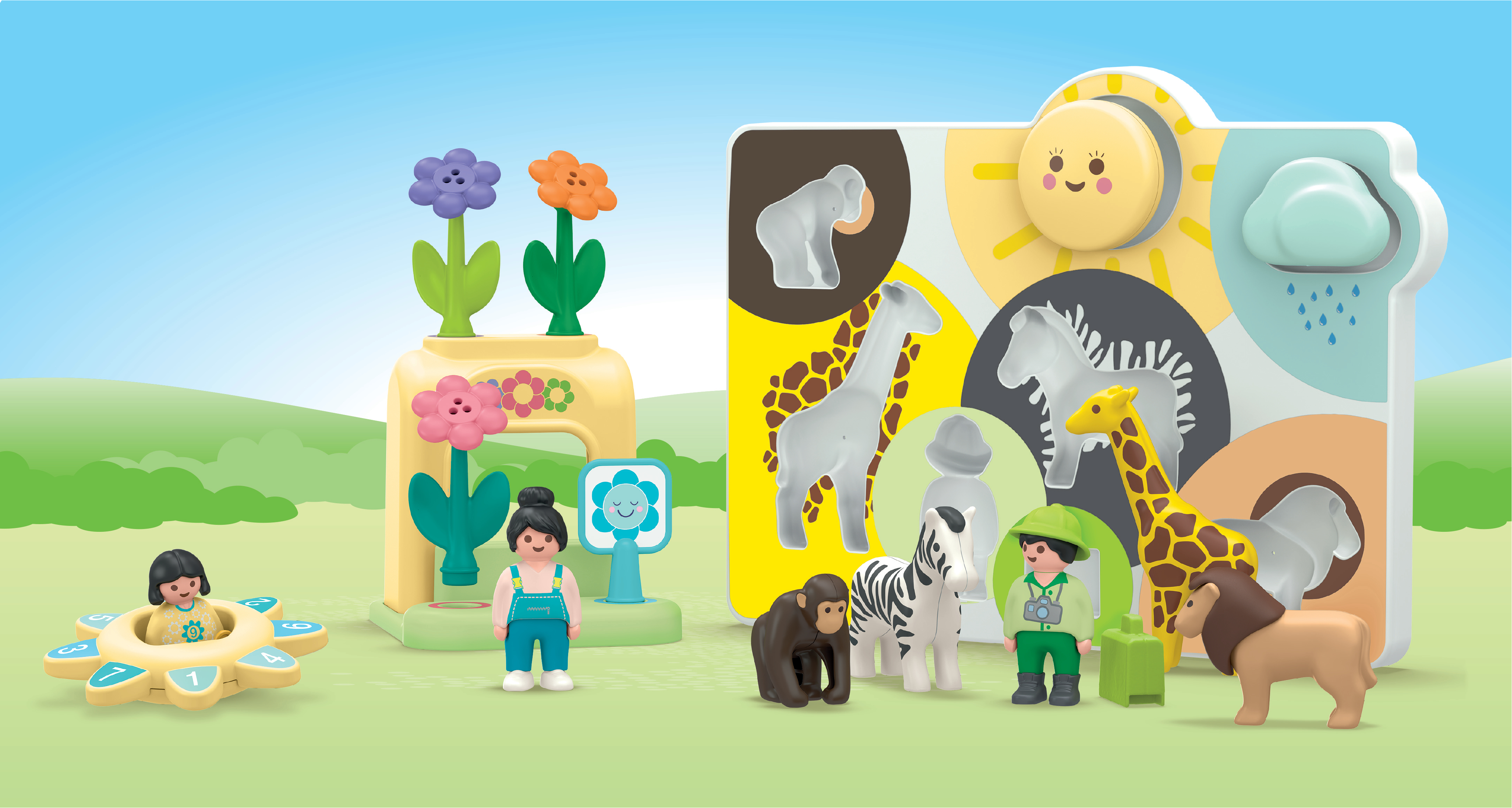 Safari de juguete con animales, figuras y flores de juguete ante un paisaje de colinas verdes.