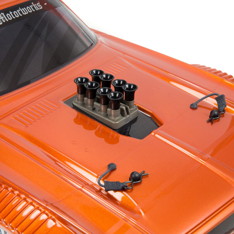 Carrocera de coche RC naranja con detalles de cap y un 'motor' de ocho tubos de escape.