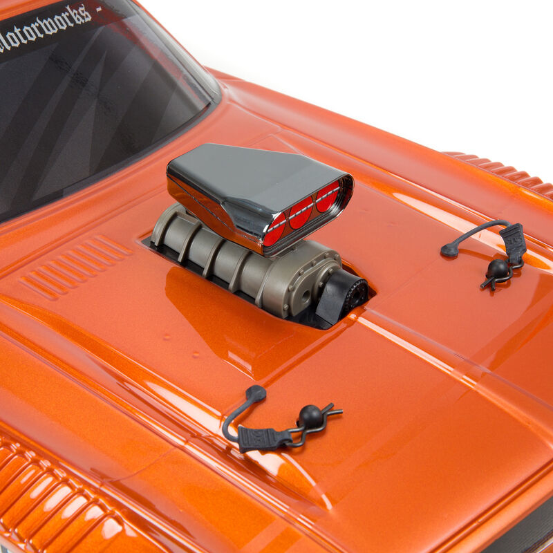 Primer plano del capó de un coche de juguete naranja, con un supercargador cromado con detalles rojos y pasadores negros.
