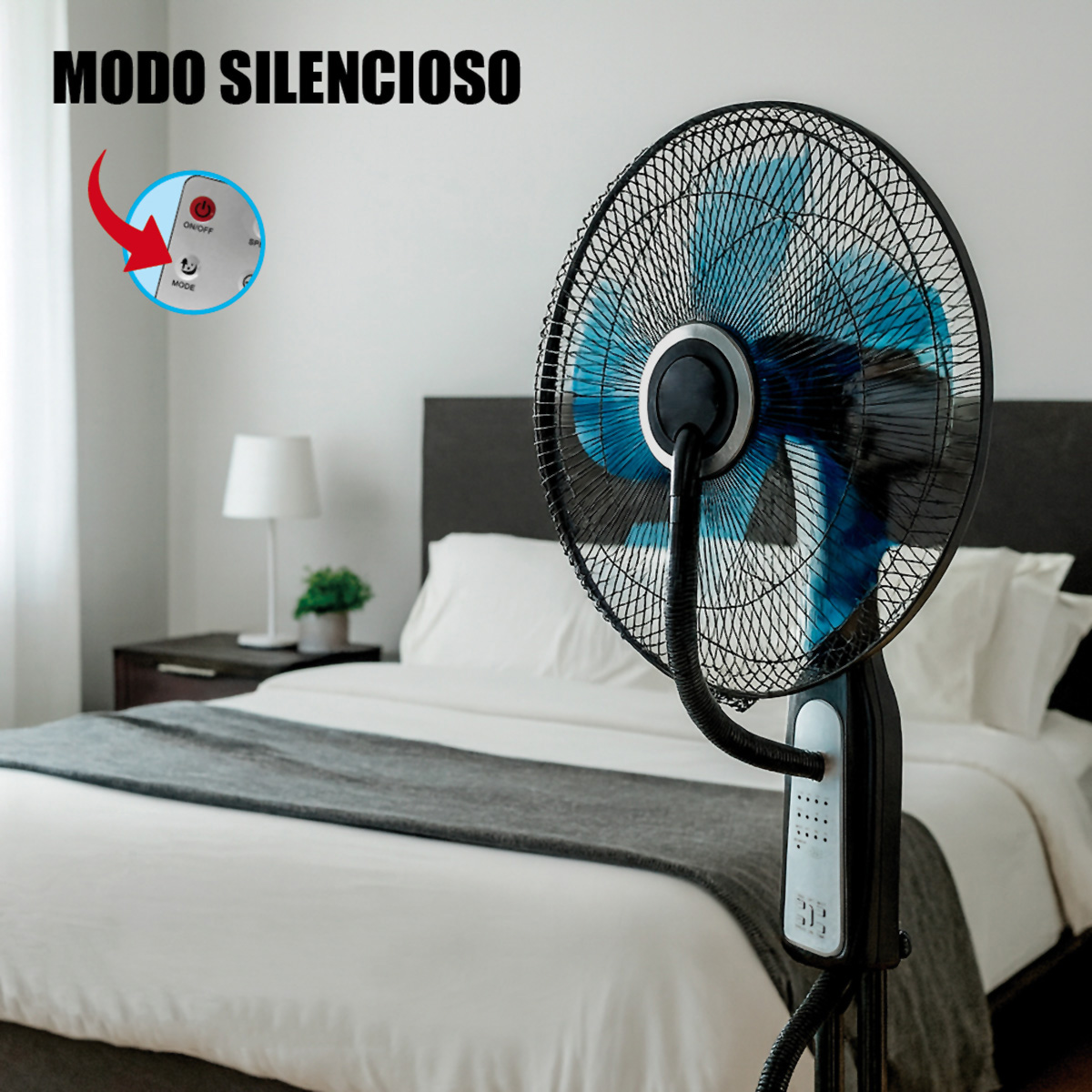 Un ventilador de pie con aspas azules frente a una cama. Se ve un mando a distancia.