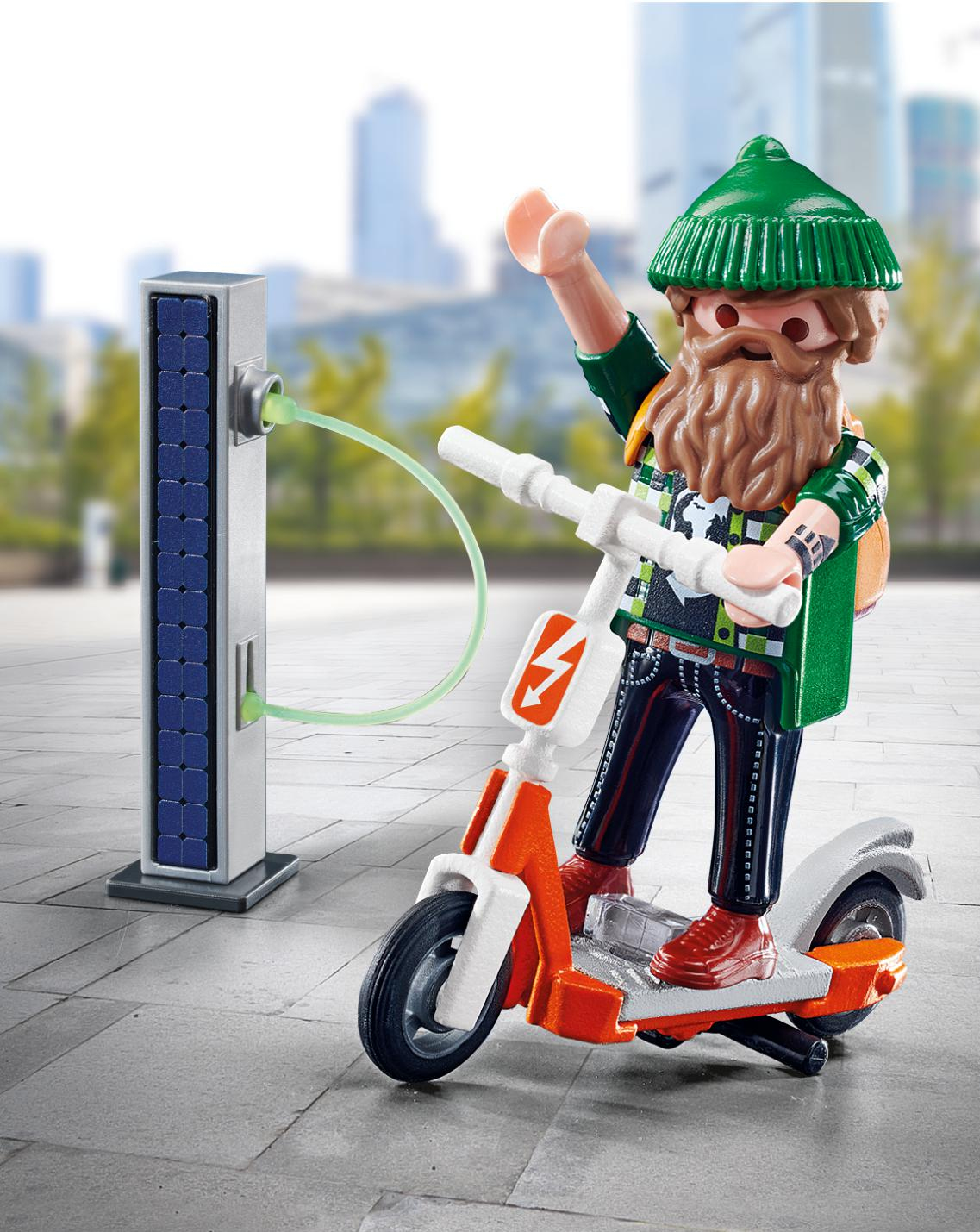 Ein Mann mit Bart und grüner Mütze auf einem E-Scooter lädt ihn an einer Solarstation auf.