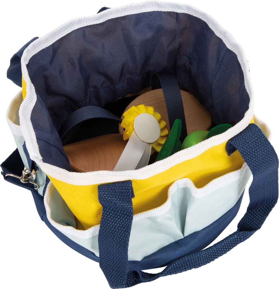 Bunte Stofftasche mit hölzernen Gegenständen, einer gelben Rosette und grünen Formen.