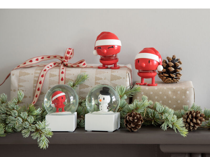 Decorazioni natalizie con globo di neve, figure e pigne.