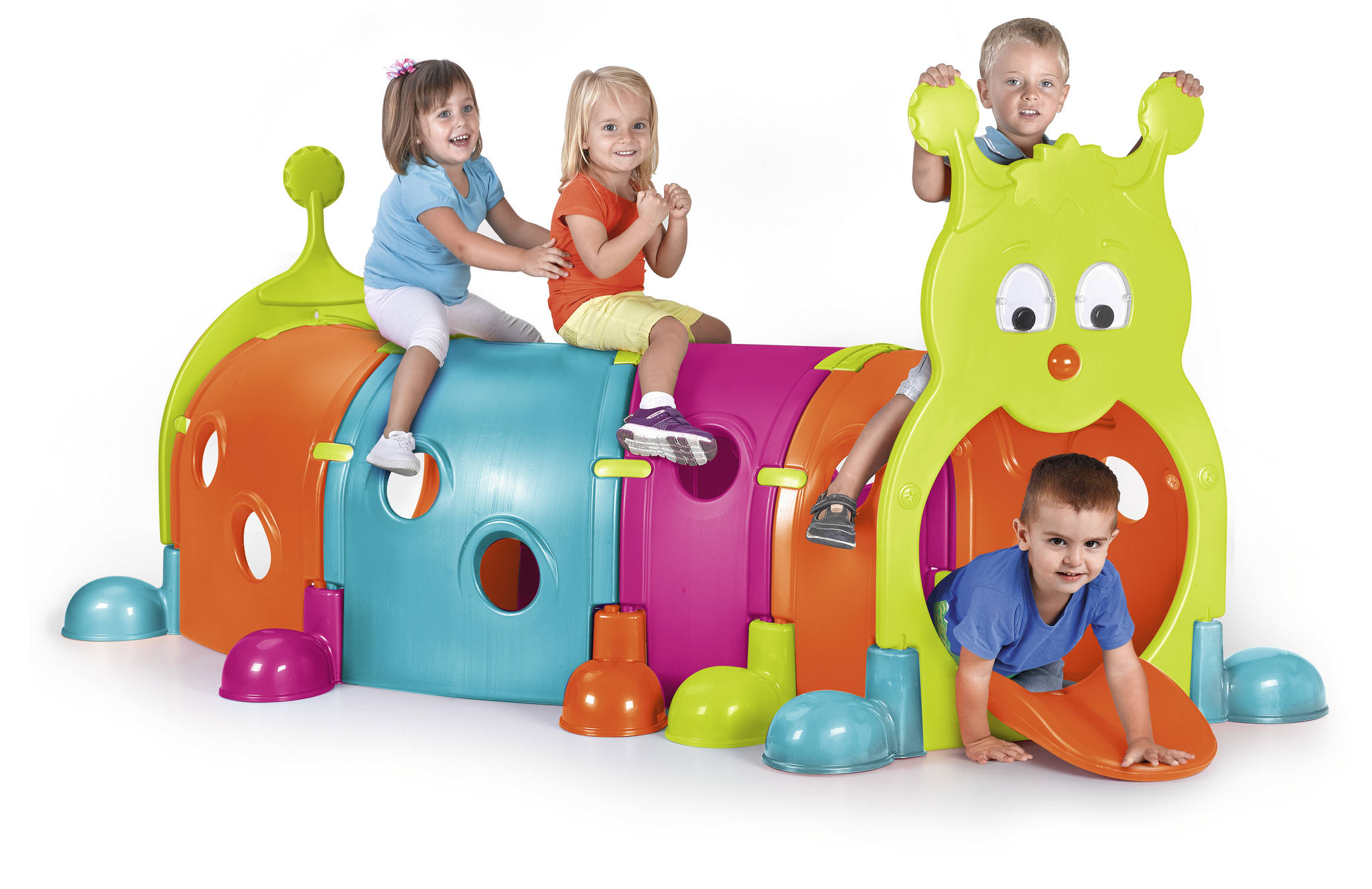 Cuatro niños juegan en un túnel de juguete colorido con forma de oruga.